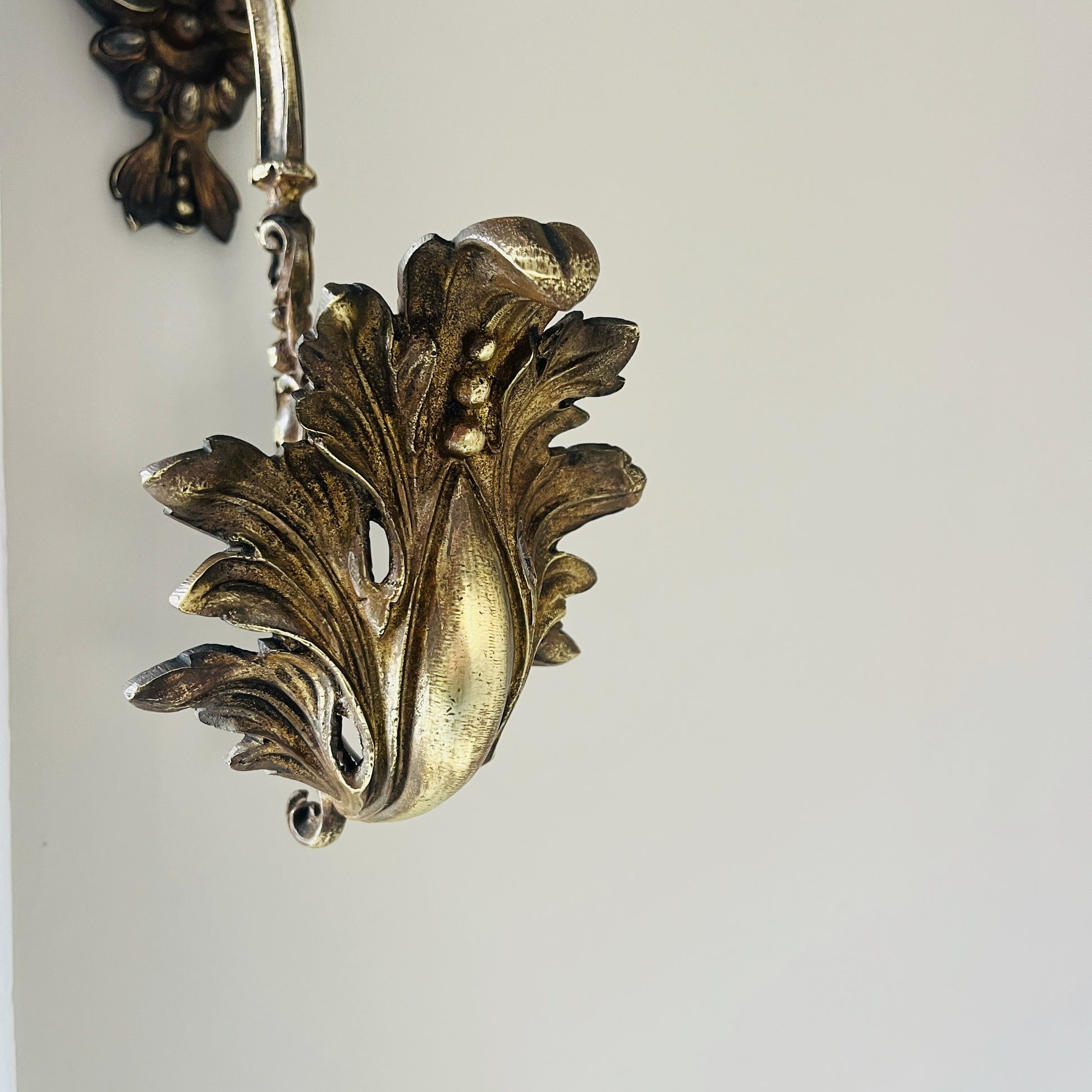 A pair of French antique ormolu tie backs from the 19th century, intricately crafted with gilded bronze, showcasing ornate floral and scroll designs, adding a touch of opulent elegance to vintage decor.