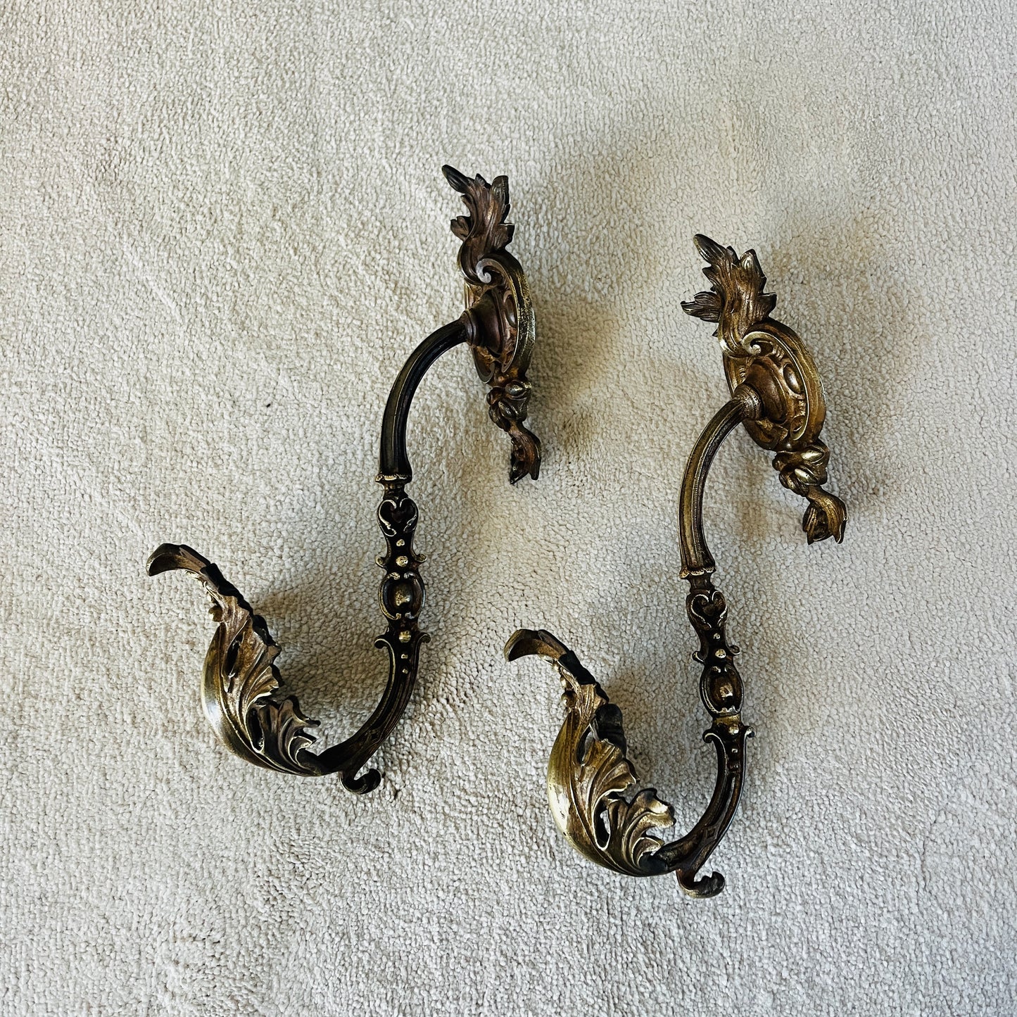 A pair of French antique ormolu tie backs from the 19th century, intricately crafted with gilded bronze, showcasing ornate floral and scroll designs, adding a touch of opulent elegance to vintage decor.