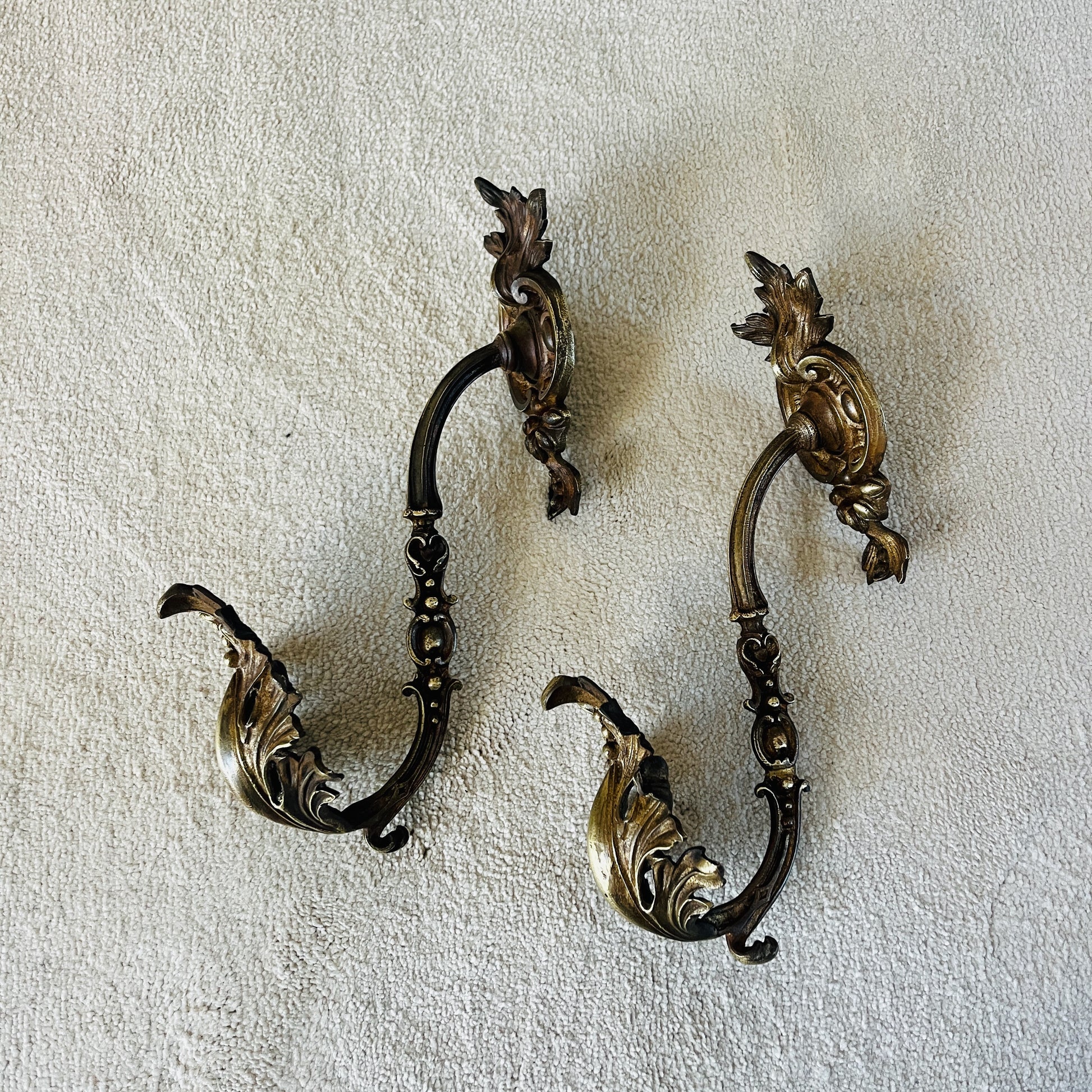 A pair of French antique ormolu tie backs from the 19th century, intricately crafted with gilded bronze, showcasing ornate floral and scroll designs, adding a touch of opulent elegance to vintage decor.