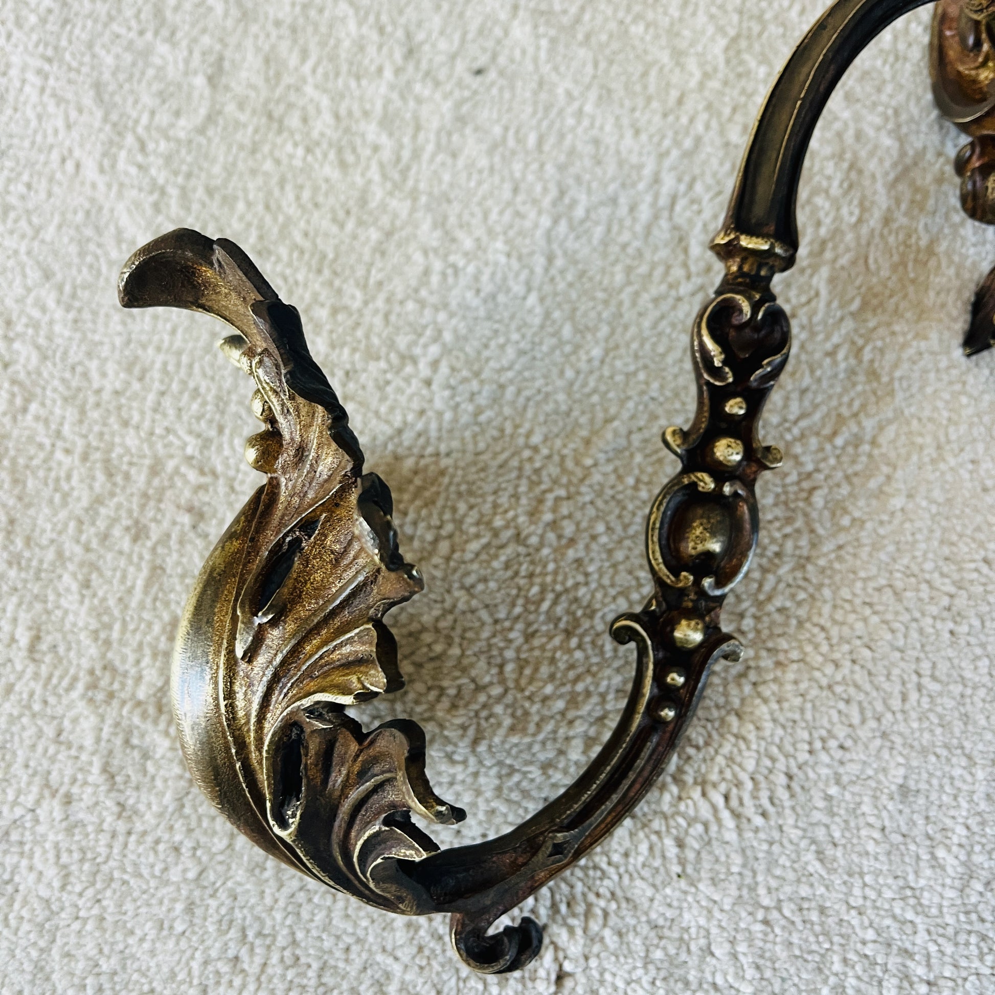 A pair of French antique ormolu tie backs from the 19th century, intricately crafted with gilded bronze, showcasing ornate floral and scroll designs, adding a touch of opulent elegance to vintage decor.