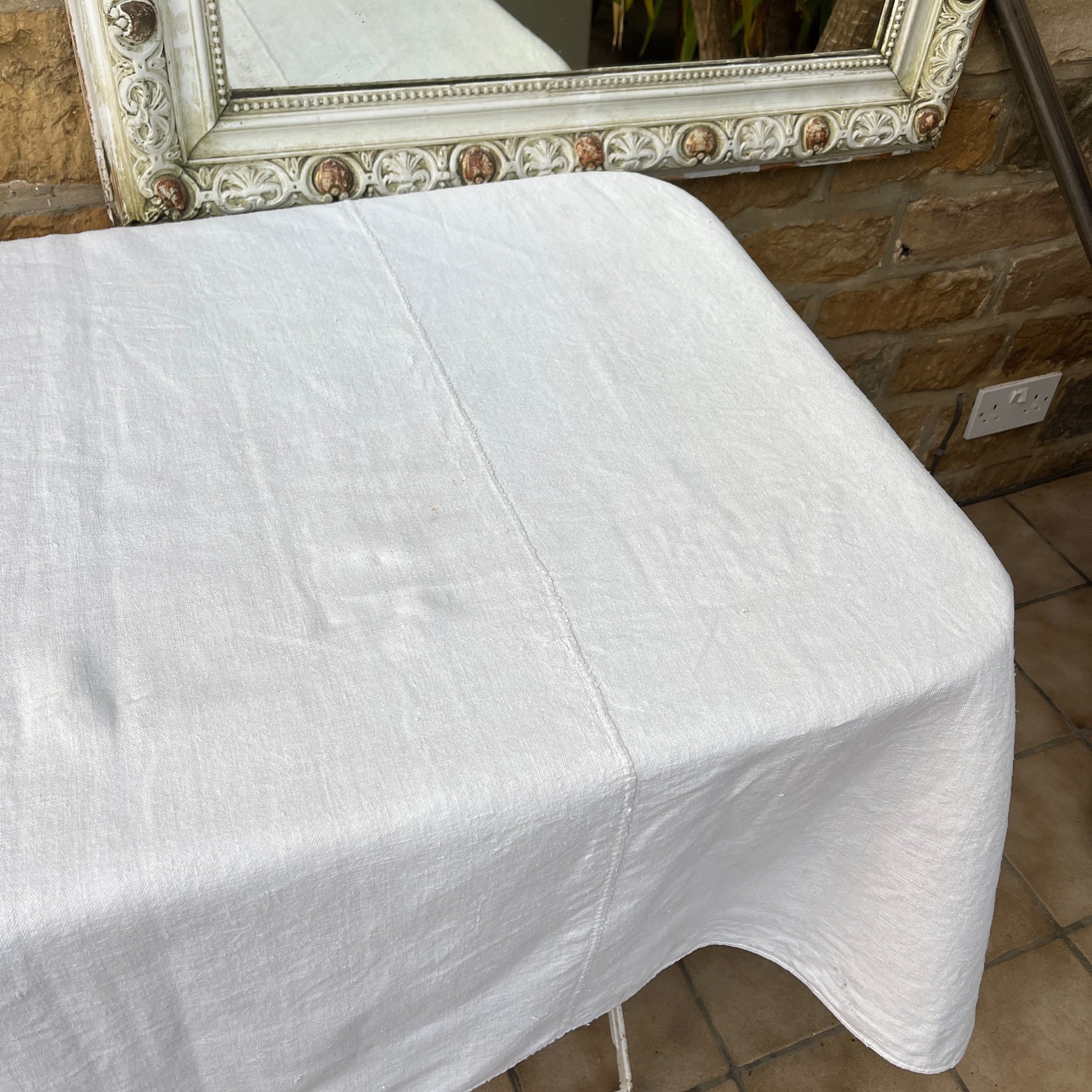 A vintage Hungarian tablecloth featuring white linen and bold red initials, showcasing traditional craftsmanship and a touch of personalized heritage.