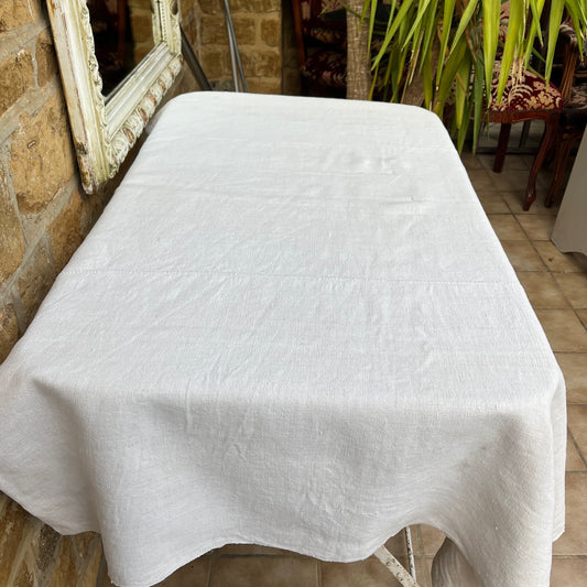 A vintage Hungarian tablecloth featuring white linen and bold red initials, showcasing traditional craftsmanship and a touch of personalized heritage.