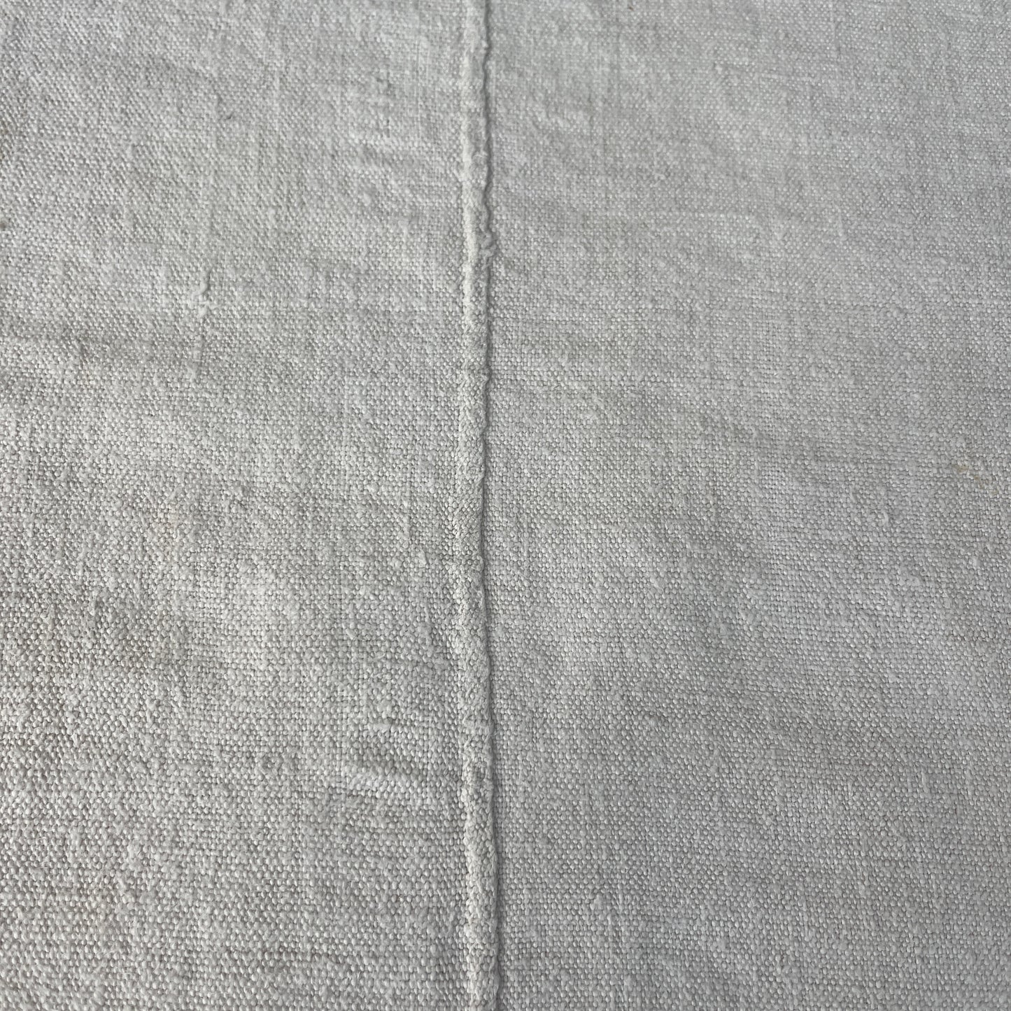 A vintage Hungarian tablecloth featuring white linen and bold red initials, showcasing traditional craftsmanship and a touch of personalized heritage.