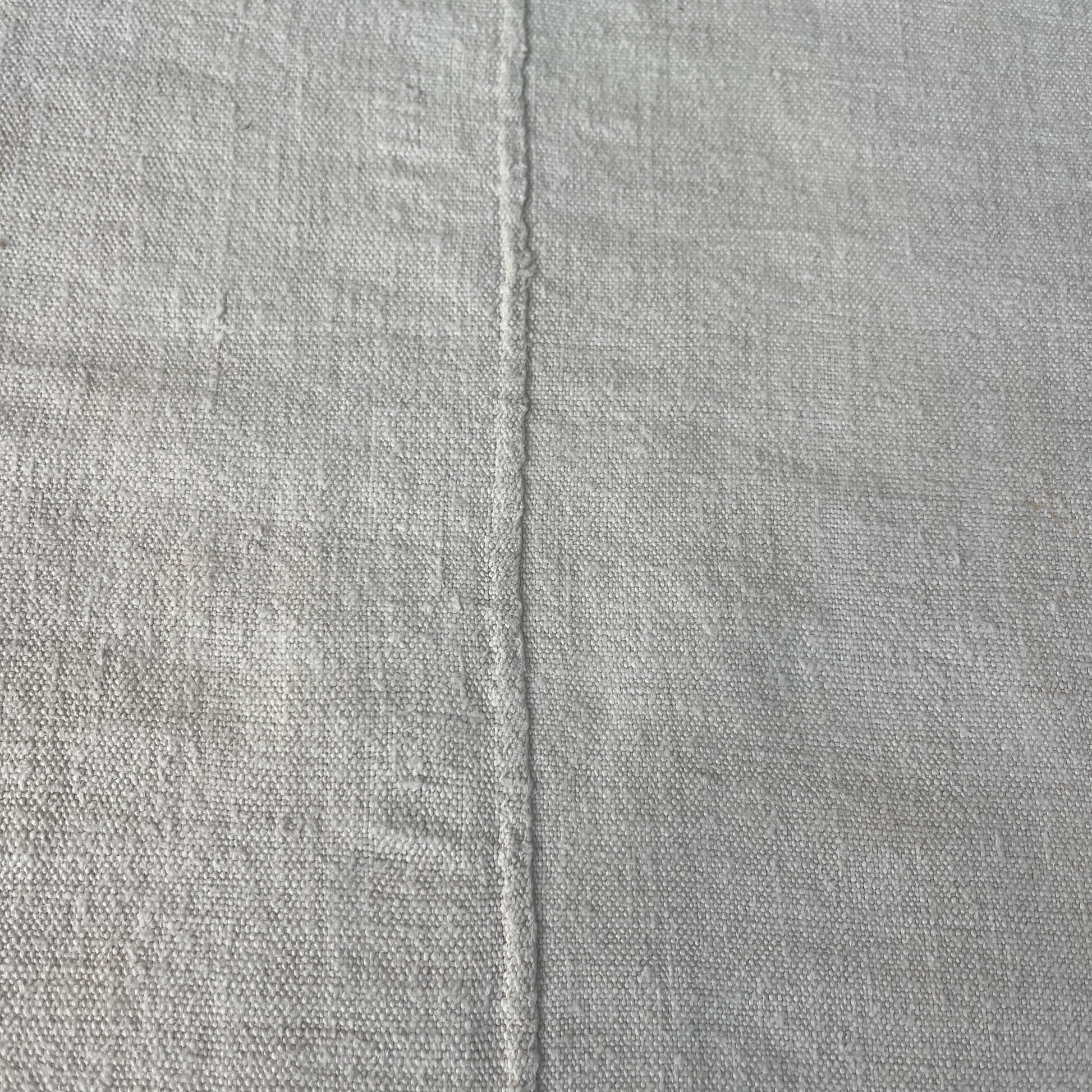 A vintage Hungarian tablecloth featuring white linen and bold red initials, showcasing traditional craftsmanship and a touch of personalized heritage.