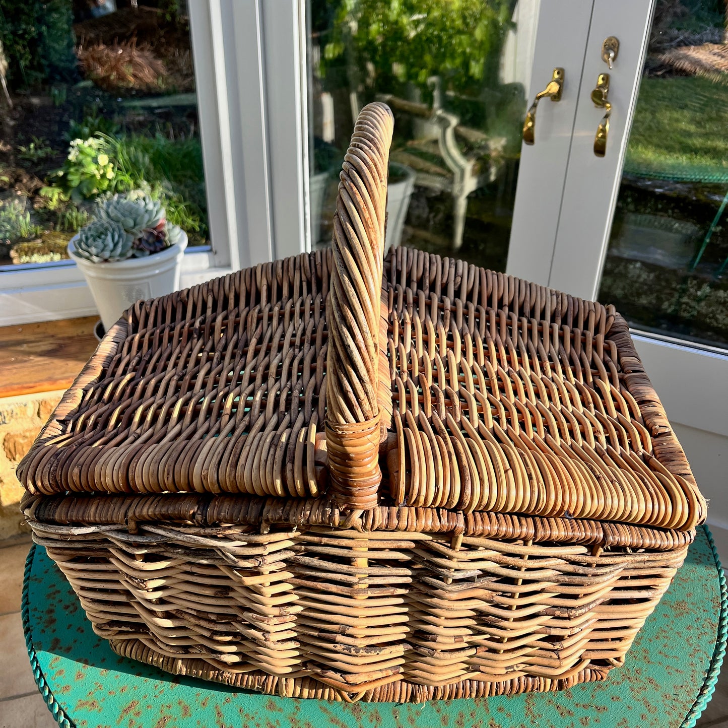 A vintage rustic picnic basket made of woven wicker, featuring two flaps and a sturdy handle on top