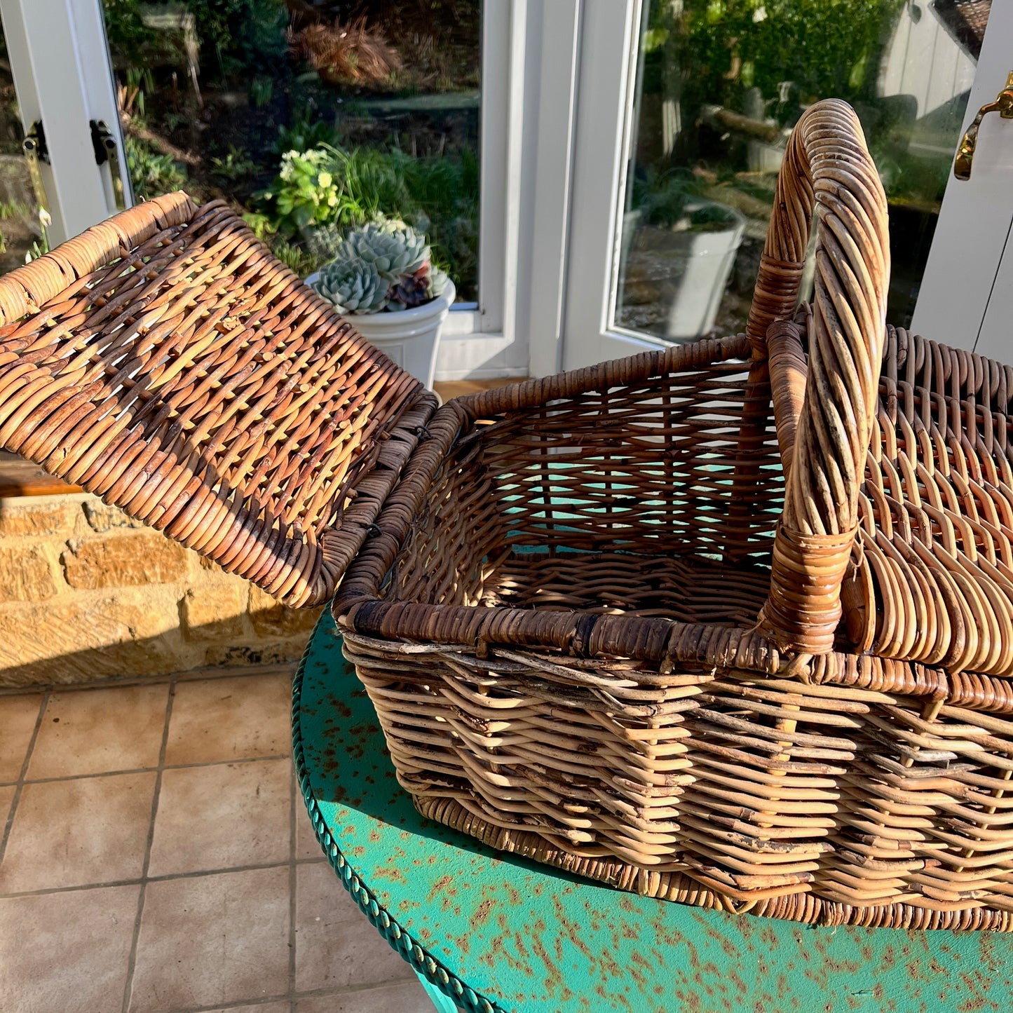 A vintage rustic picnic basket made of woven wicker, featuring two flaps and a sturdy handle on top
