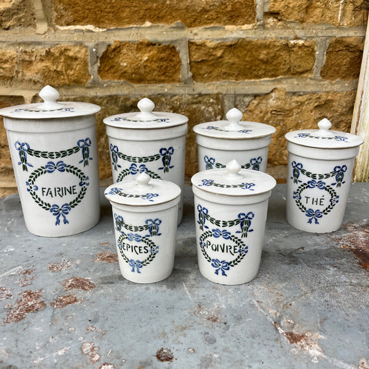 Set of ceramic storage jars with French text and decorative elements