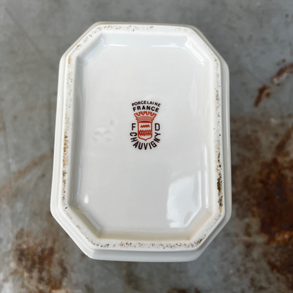 Five white ceramic kitchen canisters with matching lids, decorated with red cherries and black French text (Thé, Poivre, Café, etc.), arranged on a rustic gray stone surface.