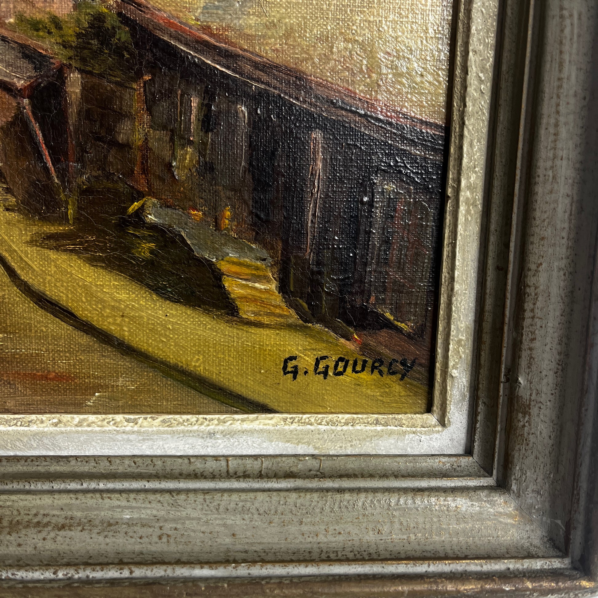 Framed painting of a village scene  in Dinan, France with houses and trees.