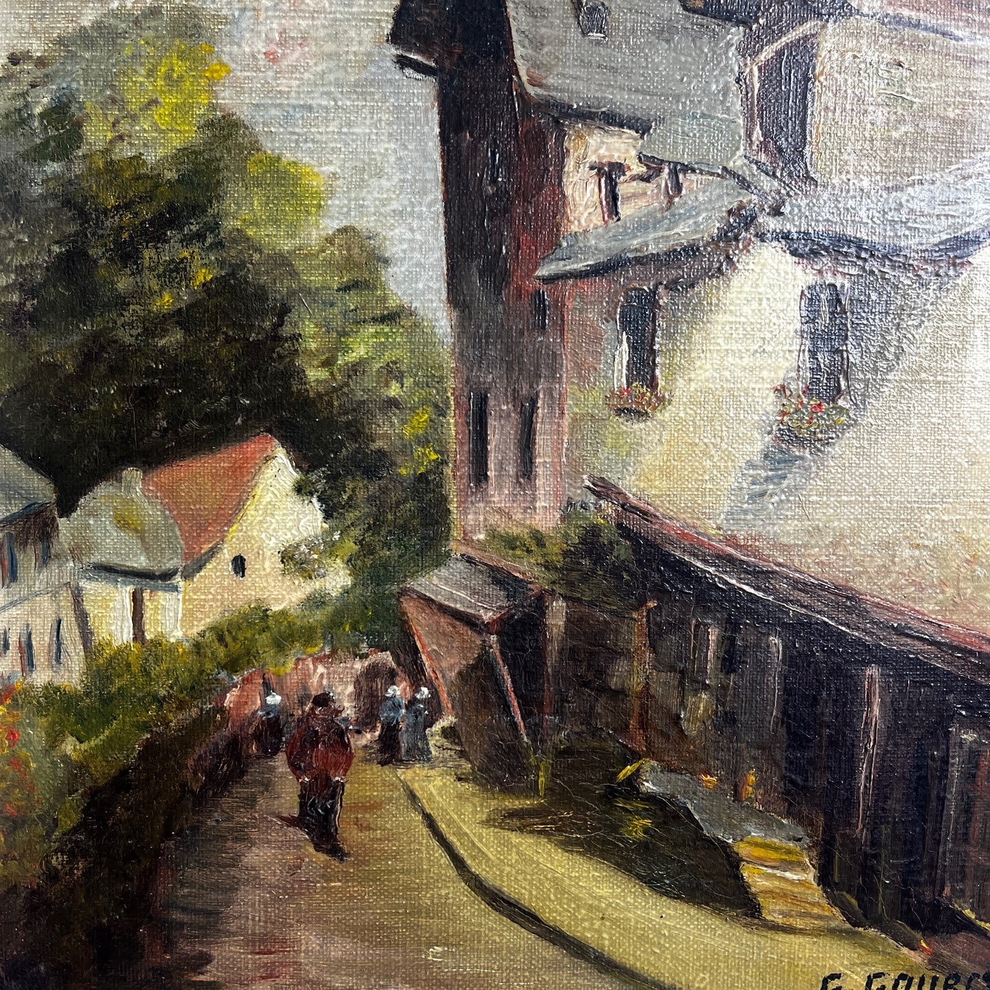 Framed painting of a village scene  in Dinan, France with houses and trees.