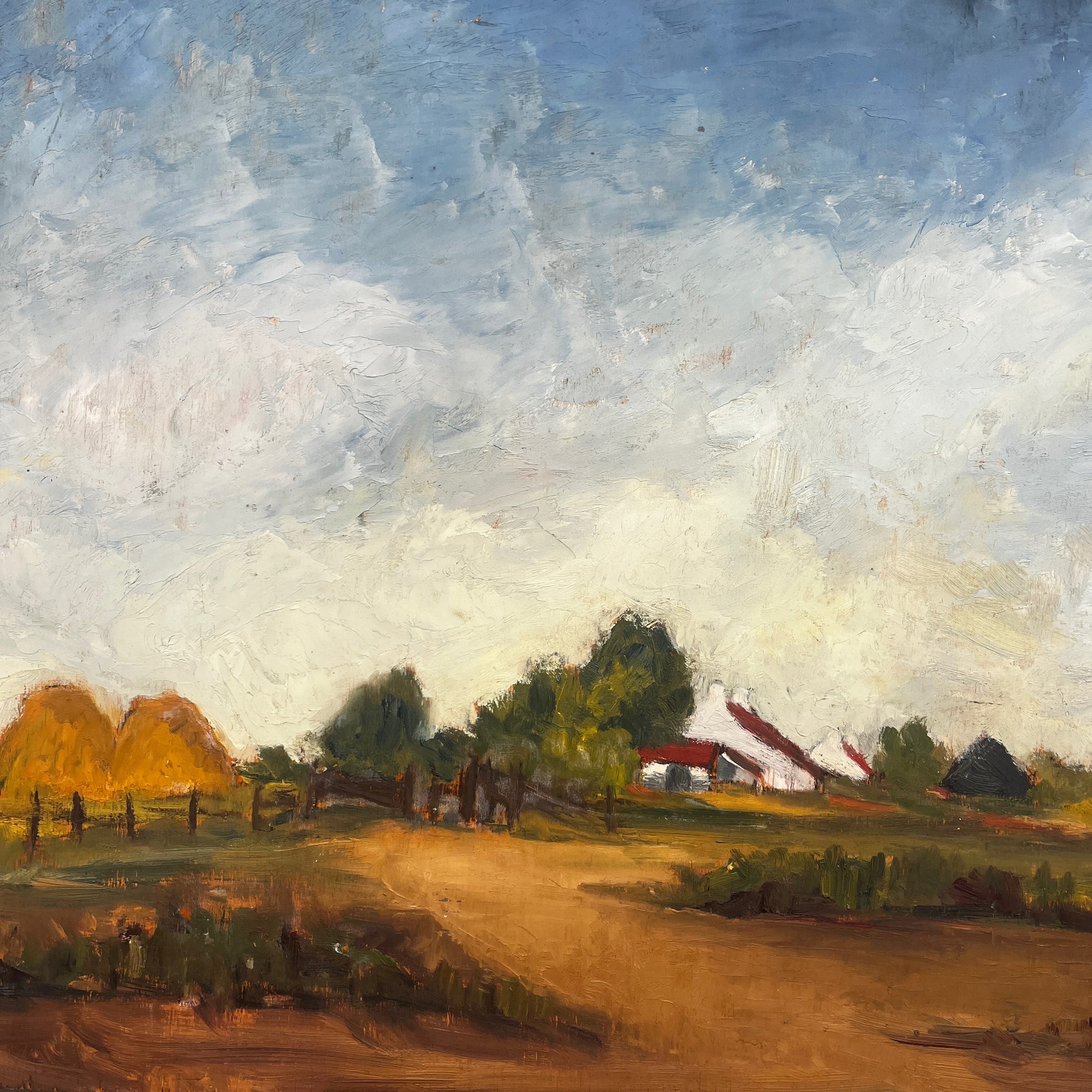 An oil landscape painting on board depicting a rural farm scene with haystacks, trees, a dirt path, and a farmhouse under a cloudy blue sky, displayed on a wooden easel.