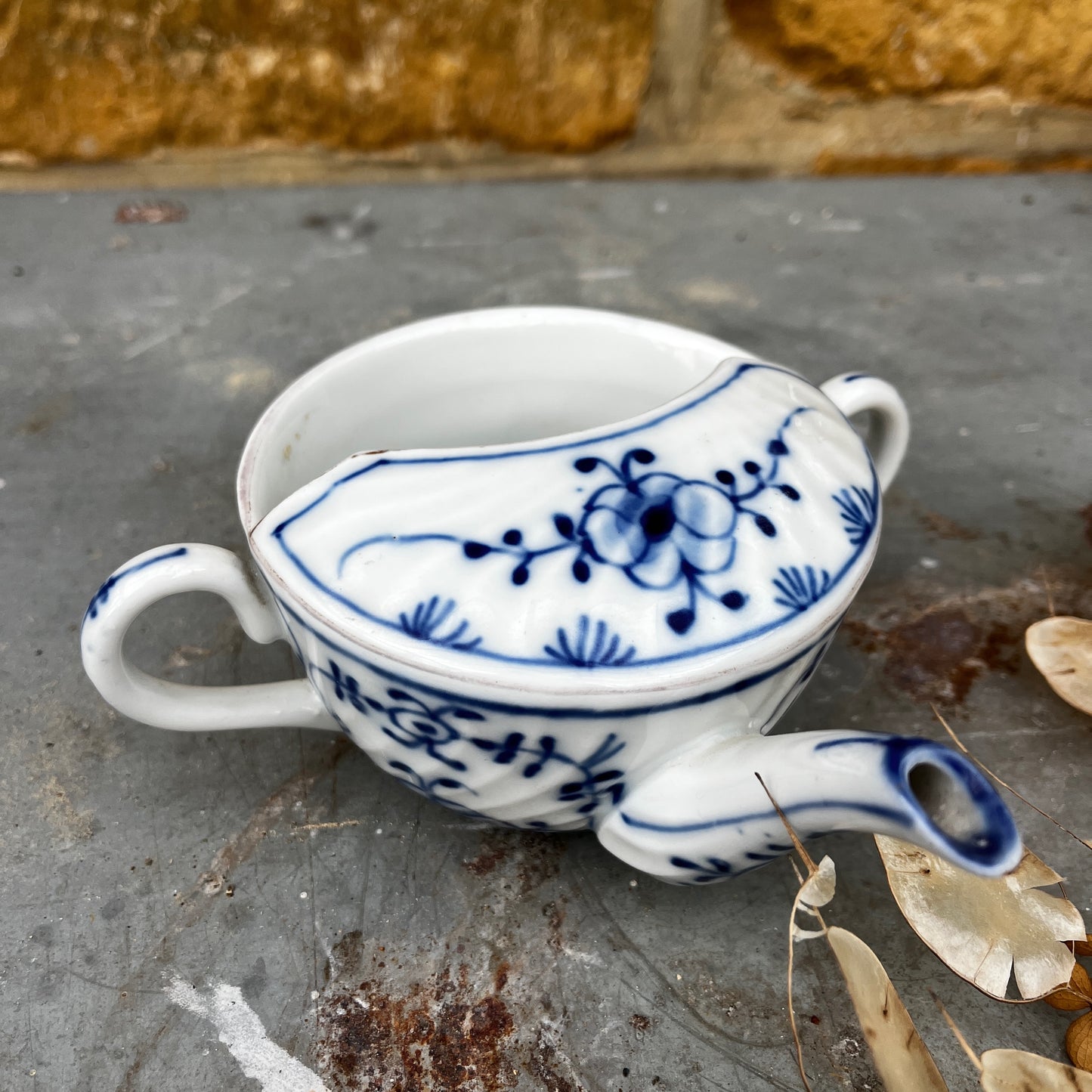 Blue and white ceramic drinking cup on a stone surface with a natural background