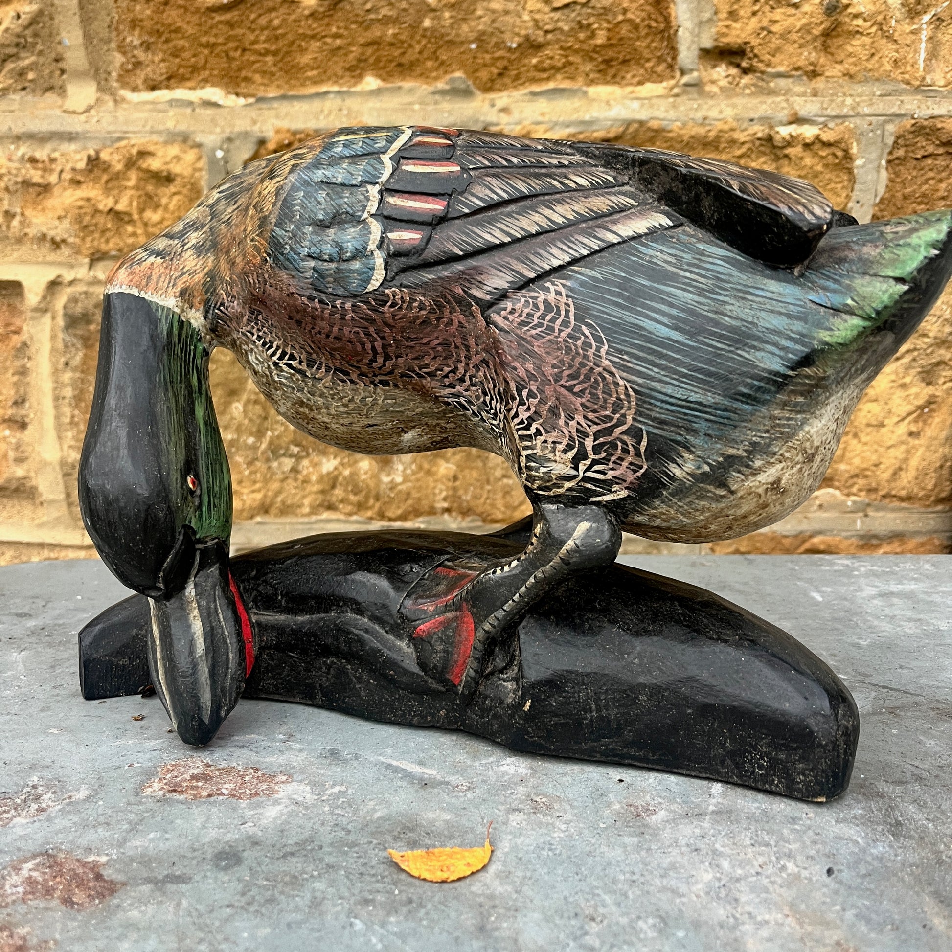 Vintage wooden duck figurine, hand-finished with painted details. The piece shows subtle signs of wear, highlighting its artisanal craftsmanship and rustic, decorative charm.