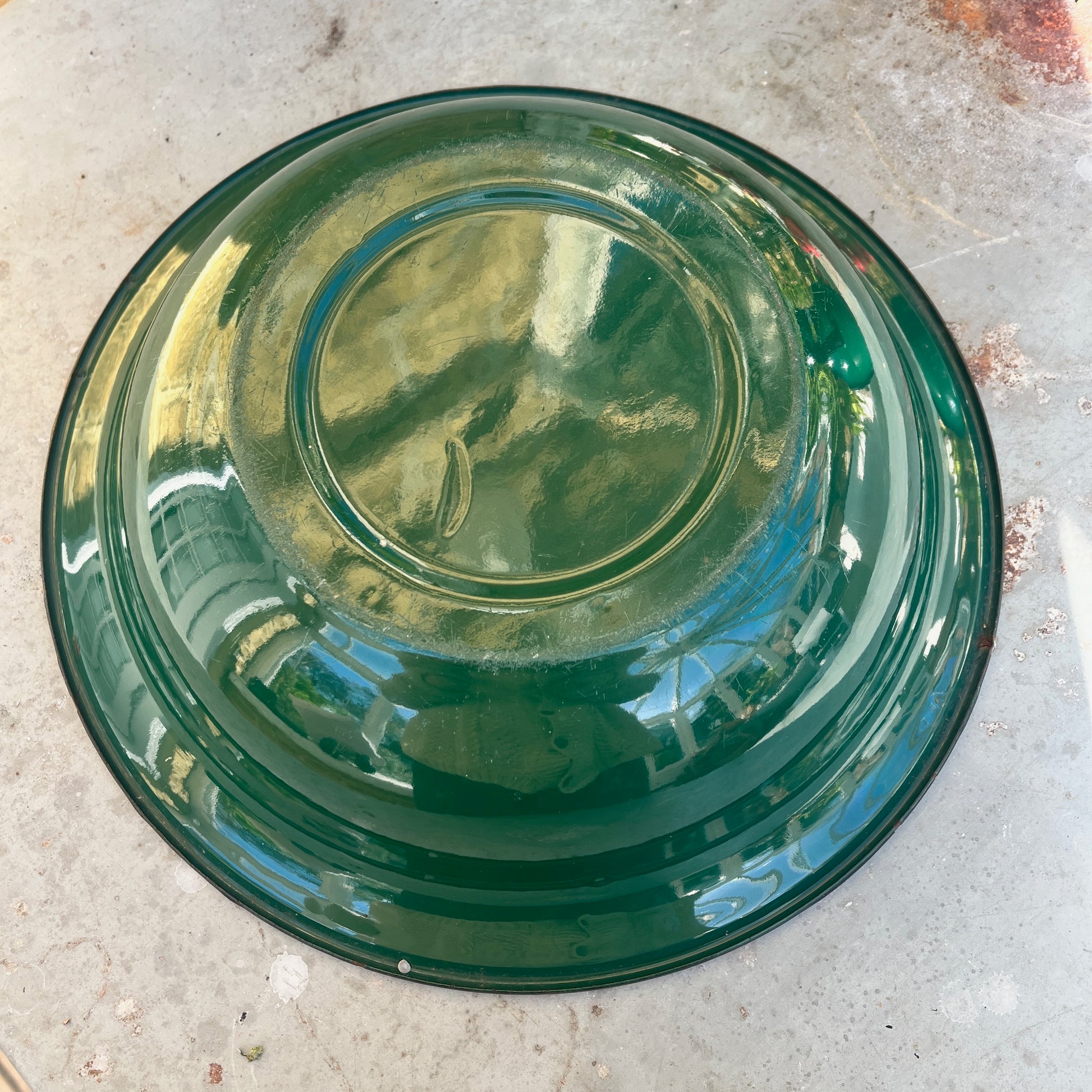 Green enamel jug and bowl set with a white interior and black detailing along the rims. The pieces feature a vintage, rustic design with a glossy finish, evoking classic enamelware style.