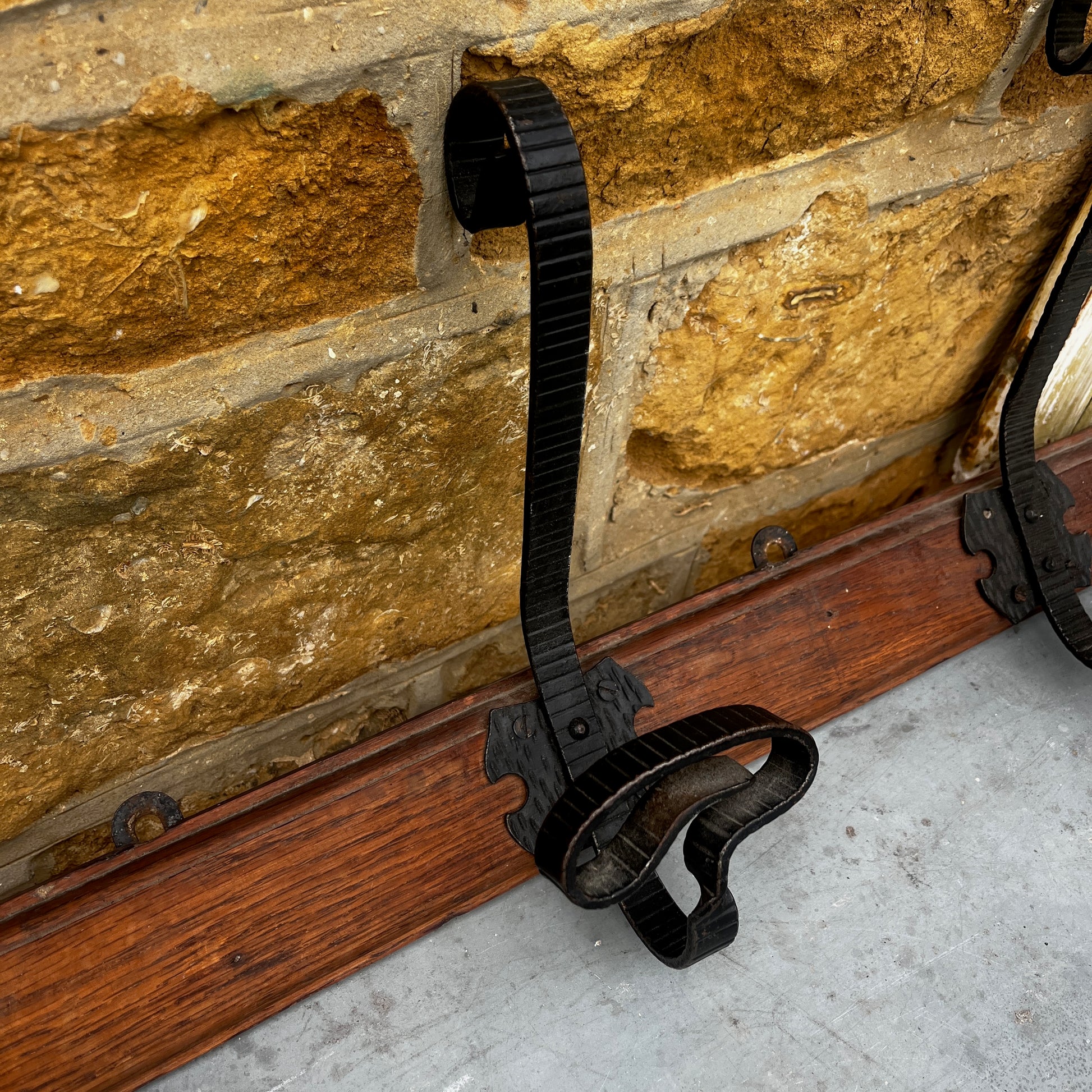 French vintage row of metal hooks mounted on a wooden backplate, featuring a rustic aged finish and classic farmhouse style.
