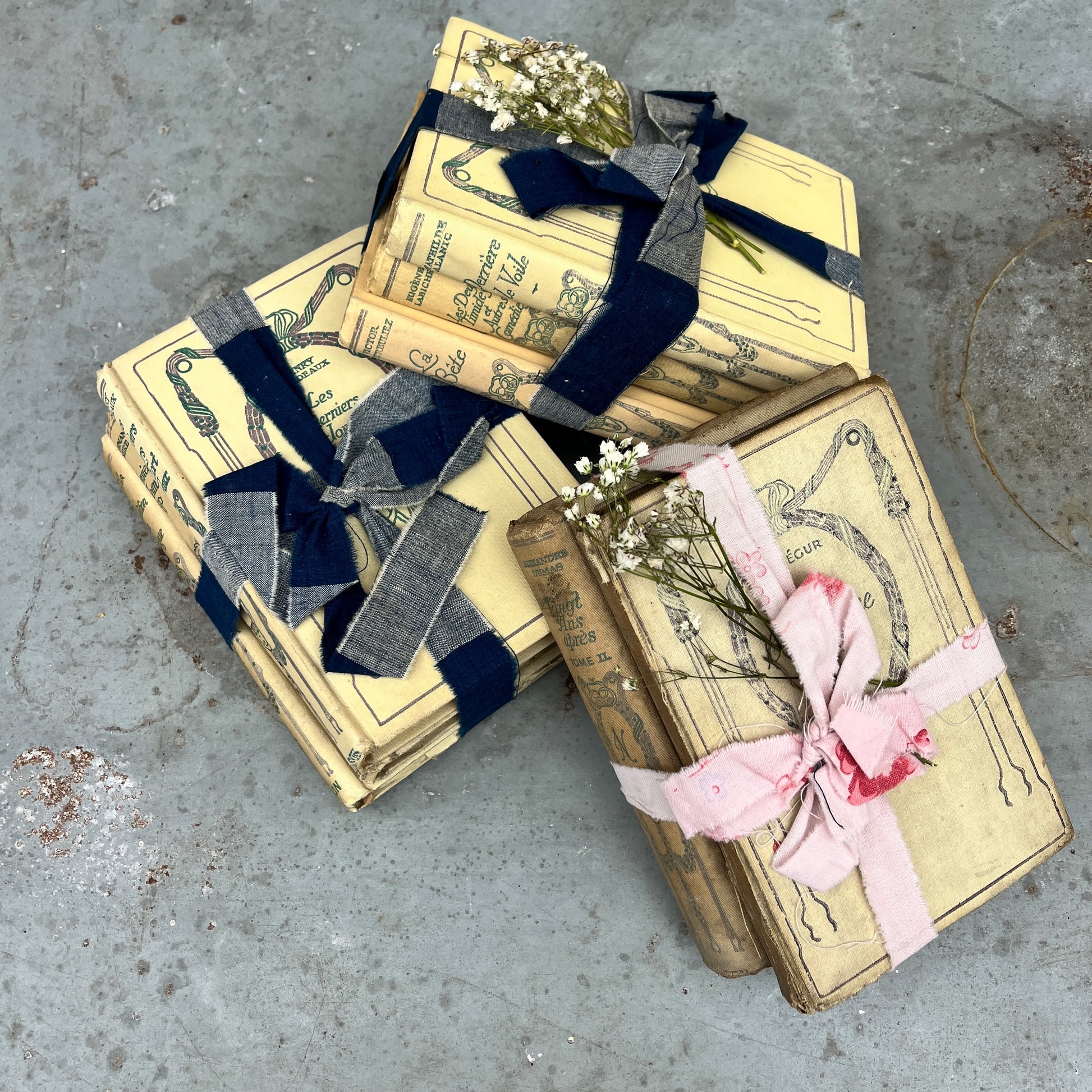 Three vintage-looking books tied with ribbons and small flowers 