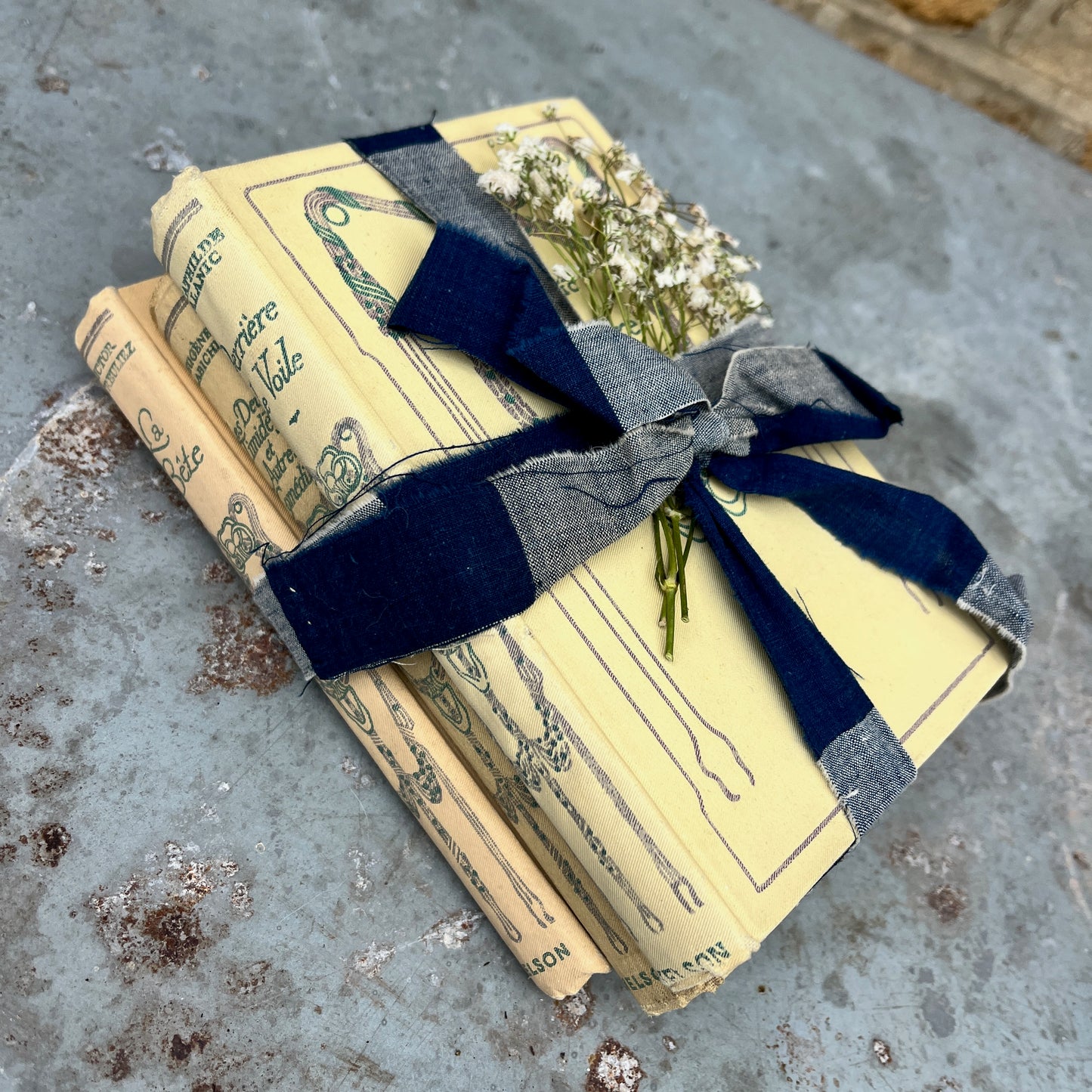 Three vintage-looking books tied with ribbons and small flowers 