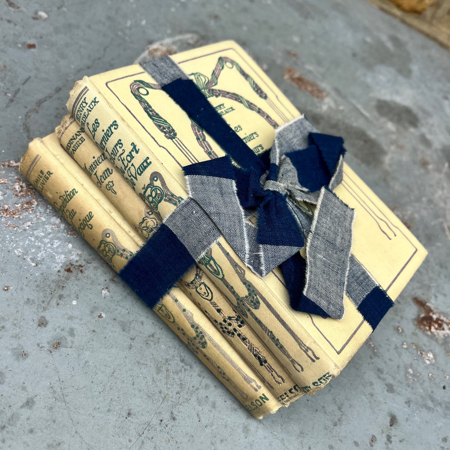 Three vintage-looking books tied with ribbons and small flowers 