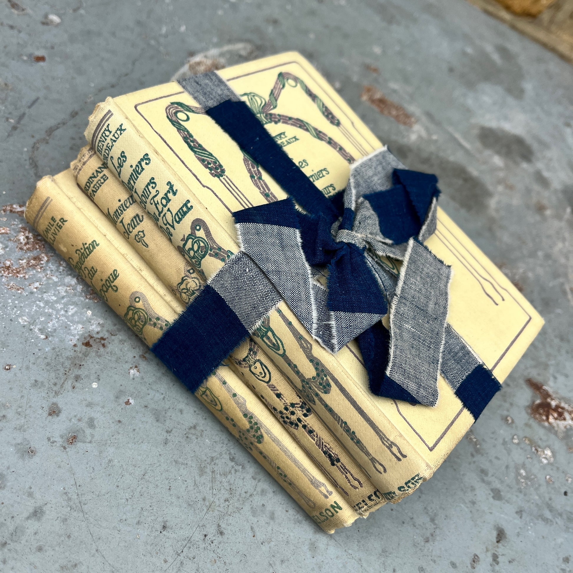 Three vintage-looking books tied with ribbons and small flowers 