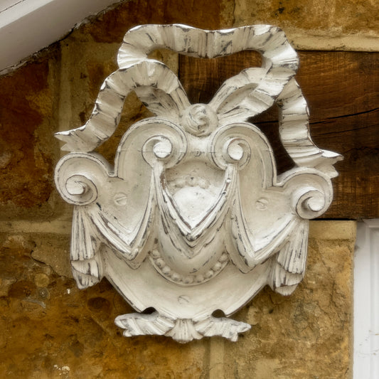 A vintage white French wall corbel with an ornate carved design and distressed finish. Featuring elegant scrollwork and decorative moulding