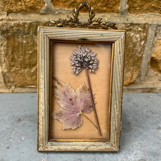 Decorative French frame with a dried flowers and gold wreath on a textured background