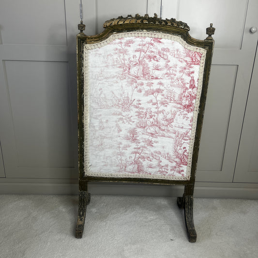 A vintage French fire screen featuring a classic Toile de Jouy fabric panel with an elegant pastoral scene in soft neutral tones