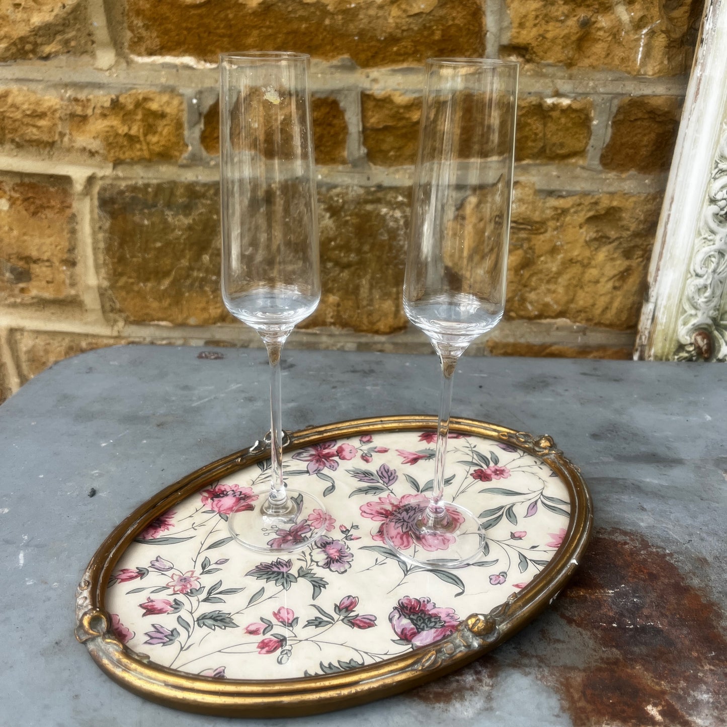 A vintage oval French gilded tray or picture frame with an ornate raised border and distressed gold finish