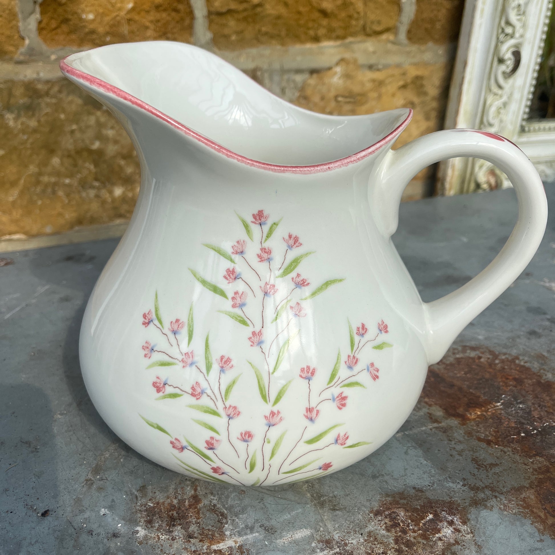 A vintage French Moulin des Loups ceramic wash basin and matching pitcher featuring a classic white glazed finish with delicate pink and green floral decoration.