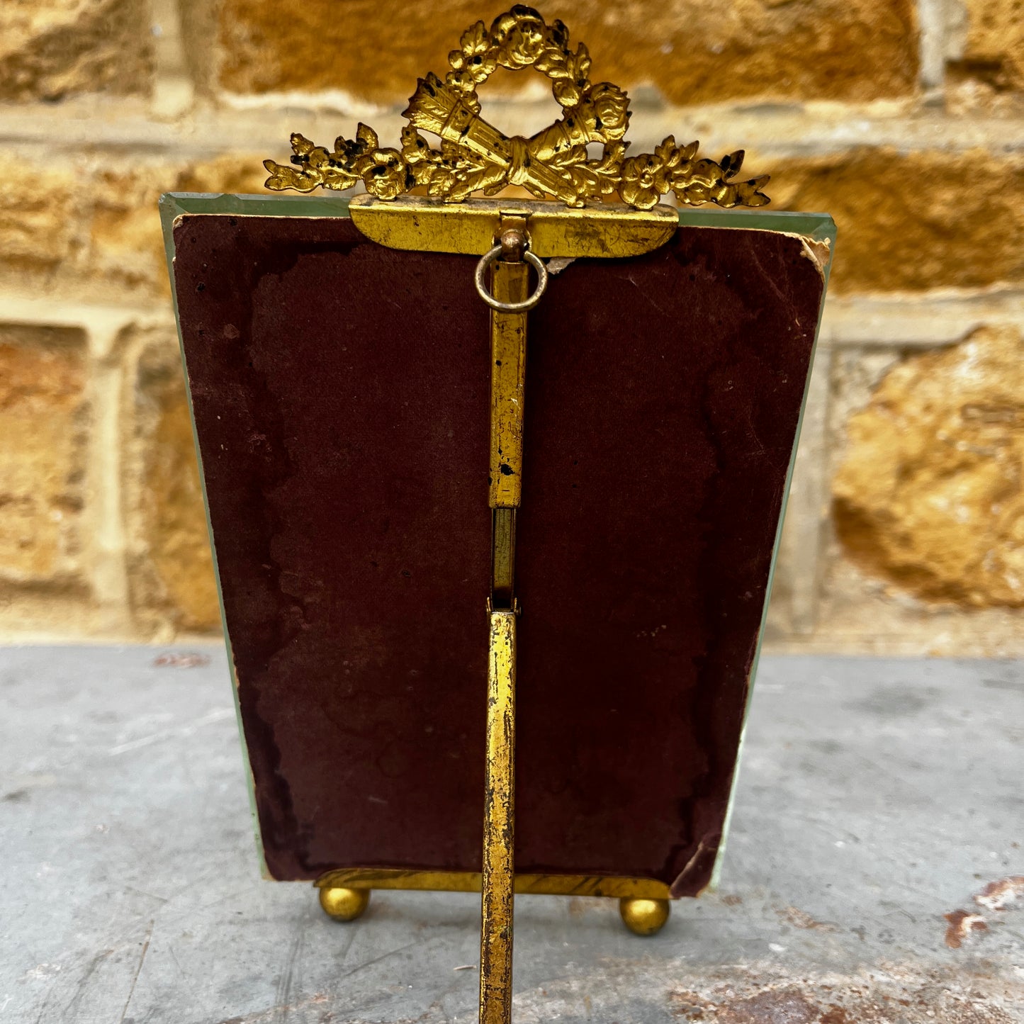 An antique French ormolu and glass photo frame featuring a bevelled glass panel and a richly aged gilt finish with a beautiful antique patina.