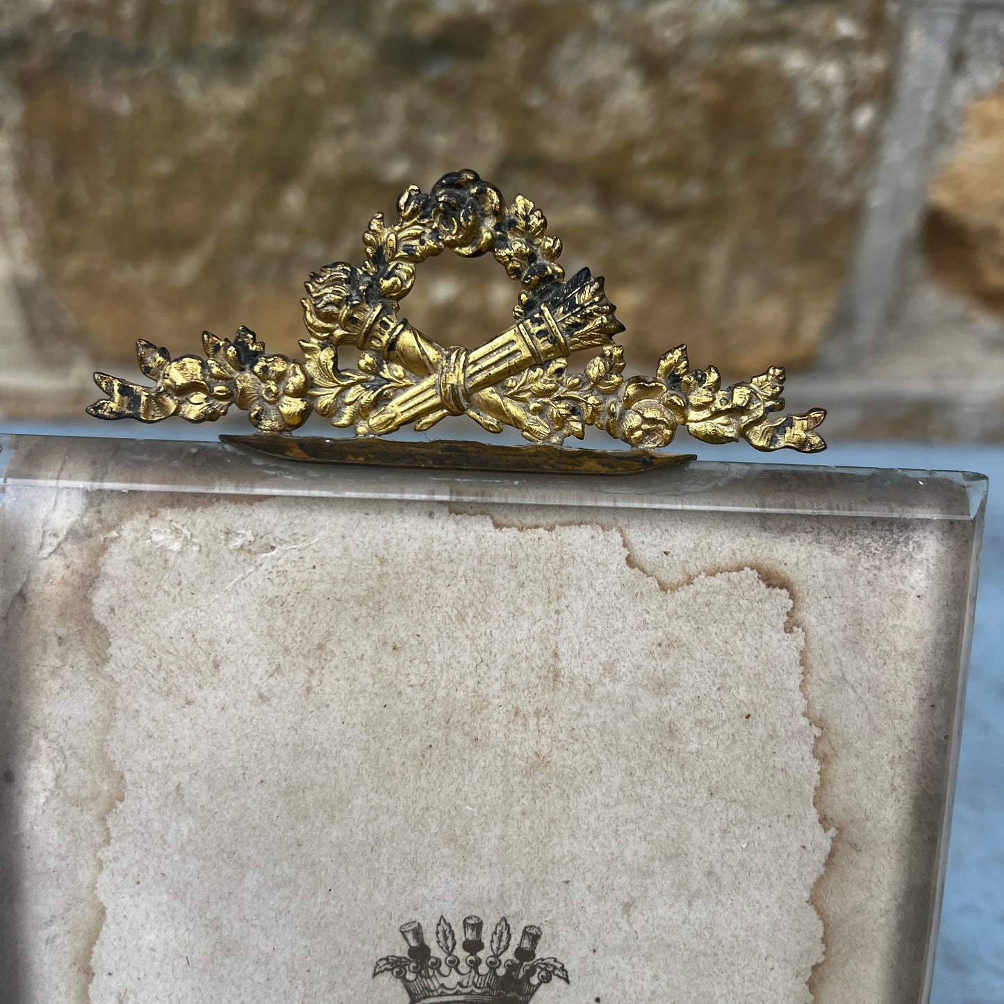 An antique French ormolu and glass photo frame featuring a bevelled glass panel and a richly aged gilt finish with a beautiful antique patina.