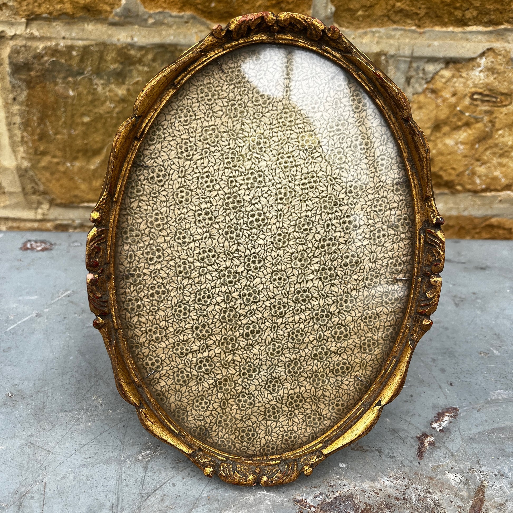 Decorative gold frame with intricate design on a textured surface
