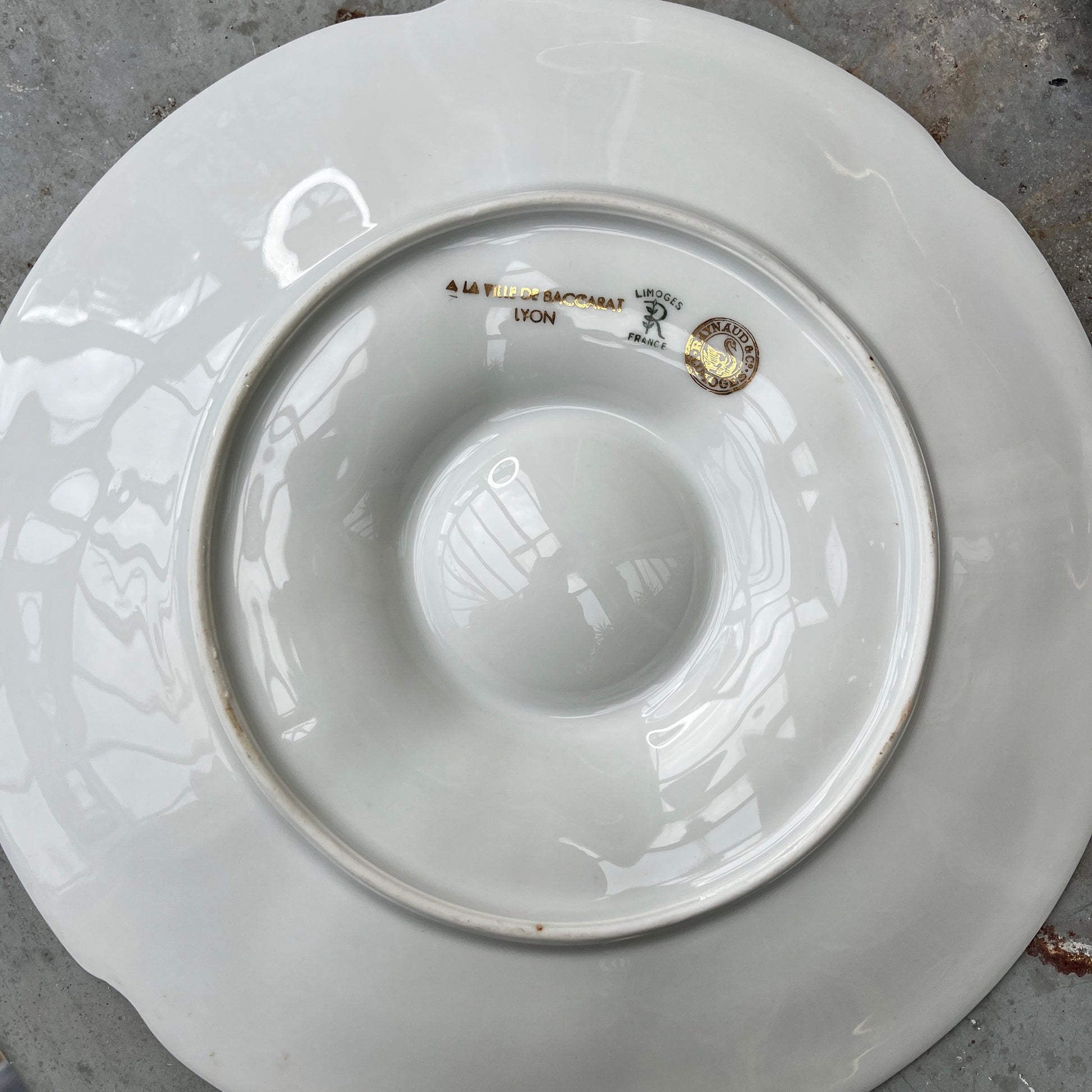 French oyster plates in white porcelain featuring elegant gold detailing along the edges. The plates have a classic, vintage design with subtle scalloped rims, reflecting refined French tableware style.