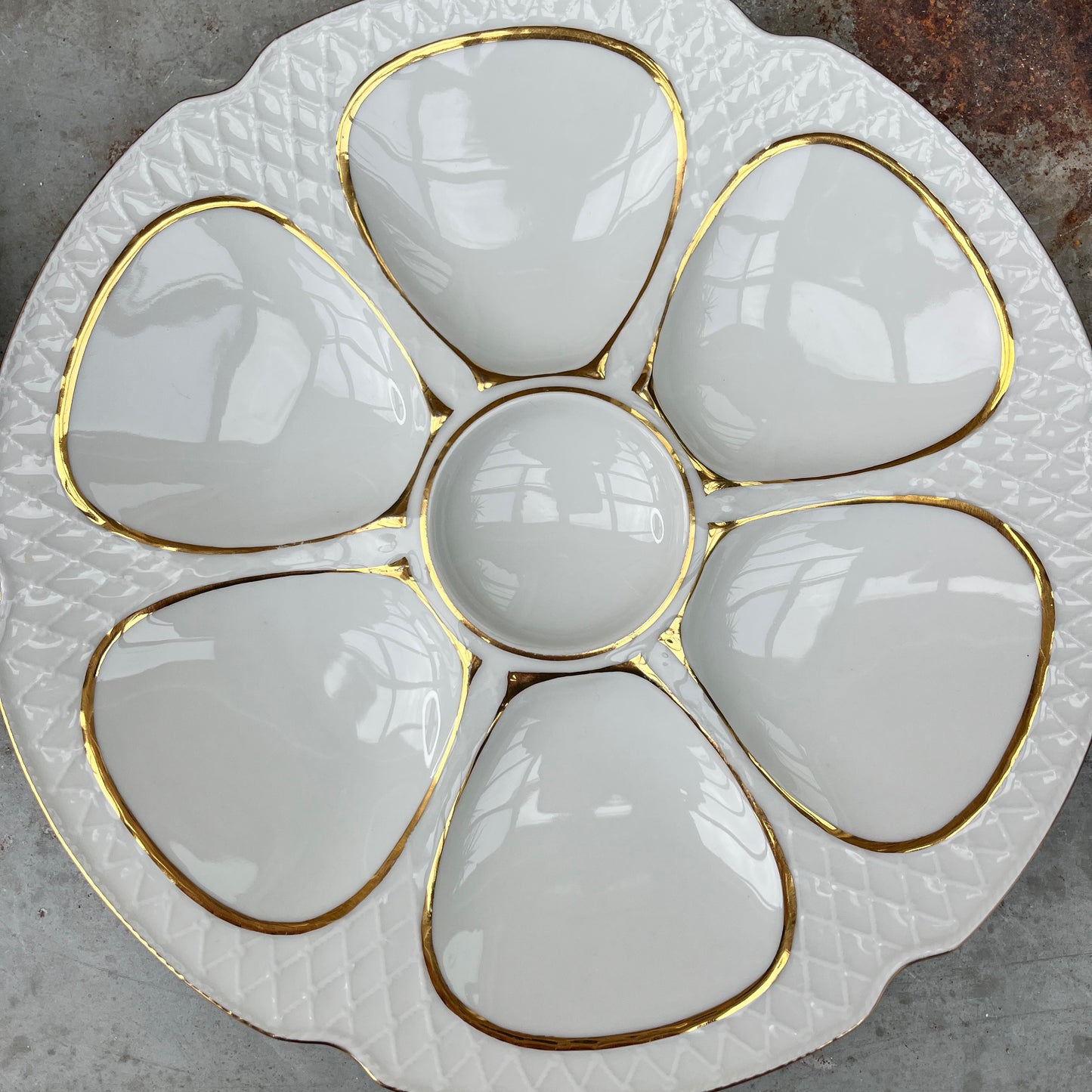 French oyster plates in white porcelain featuring elegant gold detailing along the edges. The plates have a classic, vintage design with subtle scalloped rims, reflecting refined French tableware style.