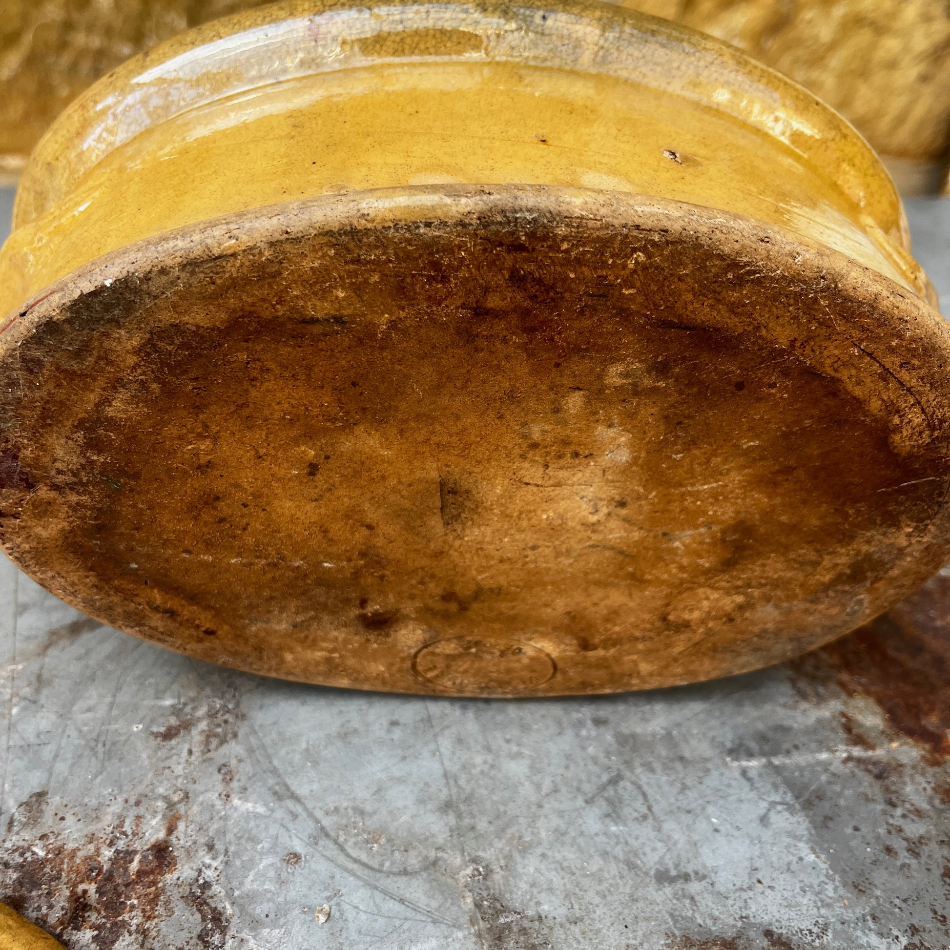 A small oval ceramic lidded french tureen dish in a warm mustard-yellow glazed finish.
