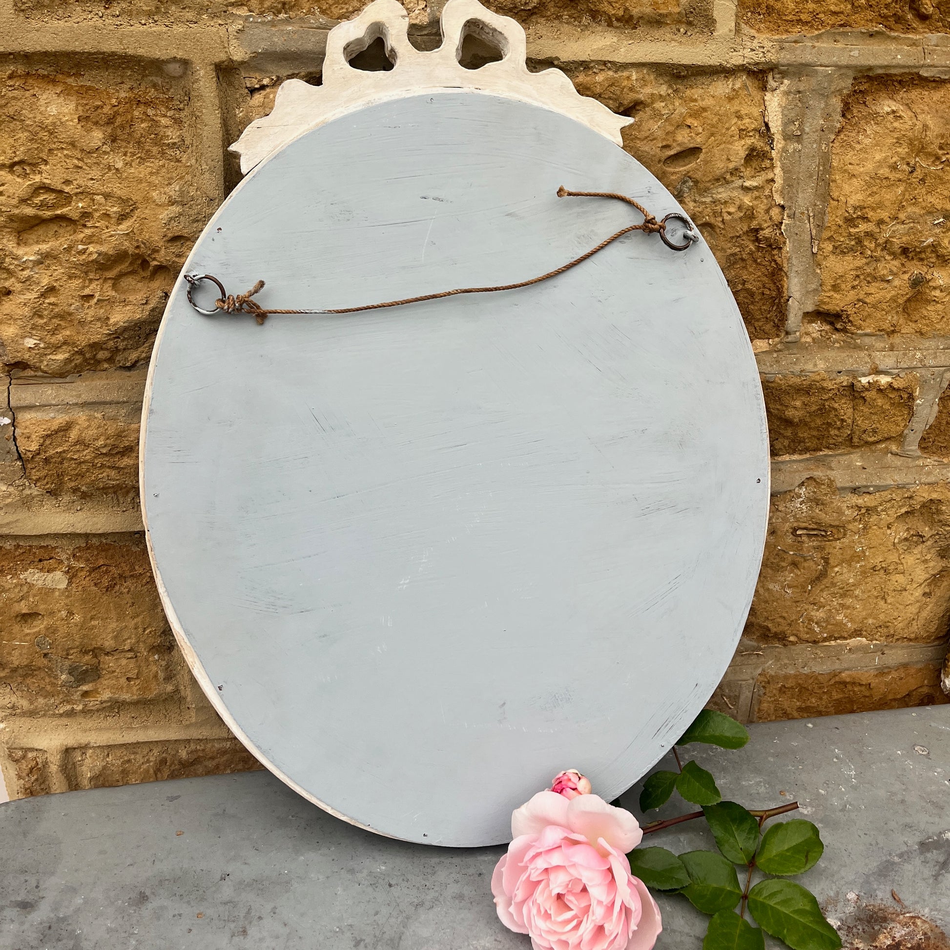 The back of a French style shabby chic oval mirror