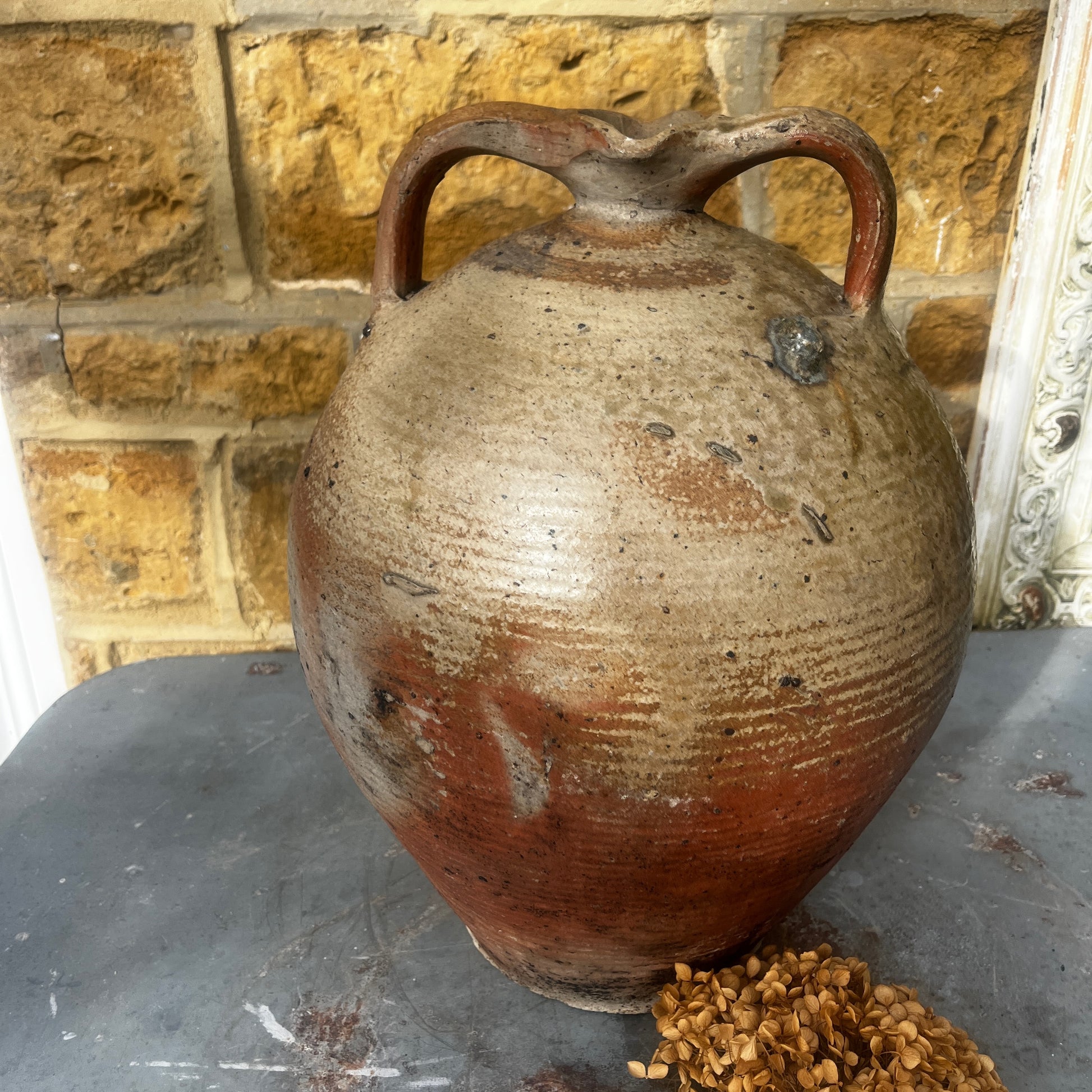 Large vintage French stoneware oil jar with a rounded body, narrow neck, and earthy glaze, showing natural patina and rustic texture typical of traditional French farmhouse pottery.
