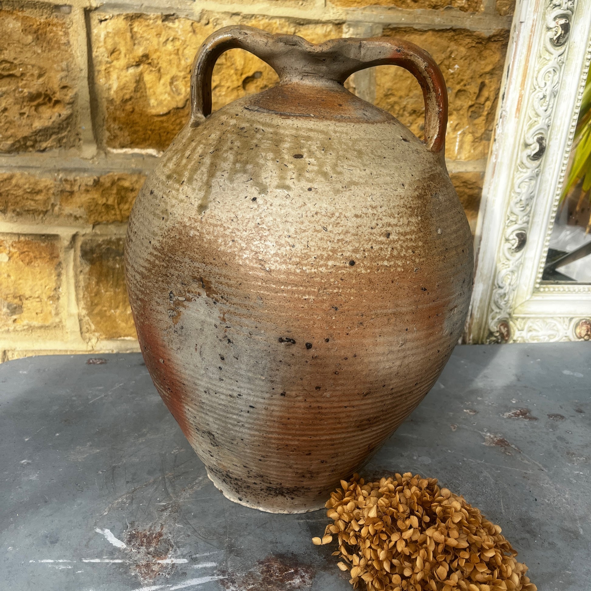 Large vintage French stoneware oil jar with a rounded body, narrow neck, and earthy glaze, showing natural patina and rustic texture typical of traditional French farmhouse pottery.