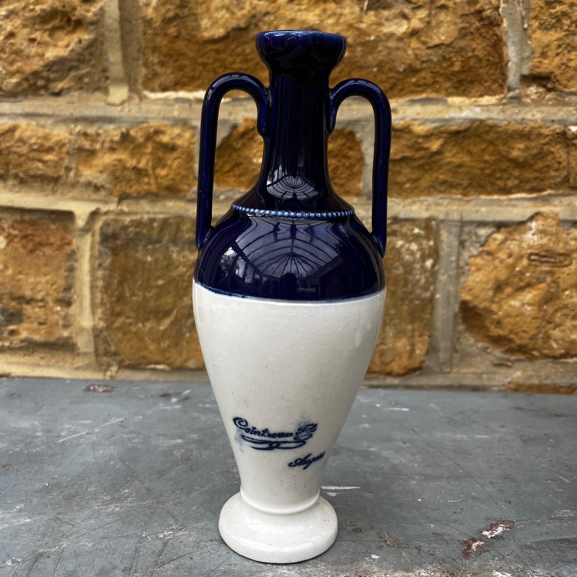 Vase with blue and white design on a stone surface and brick wall background