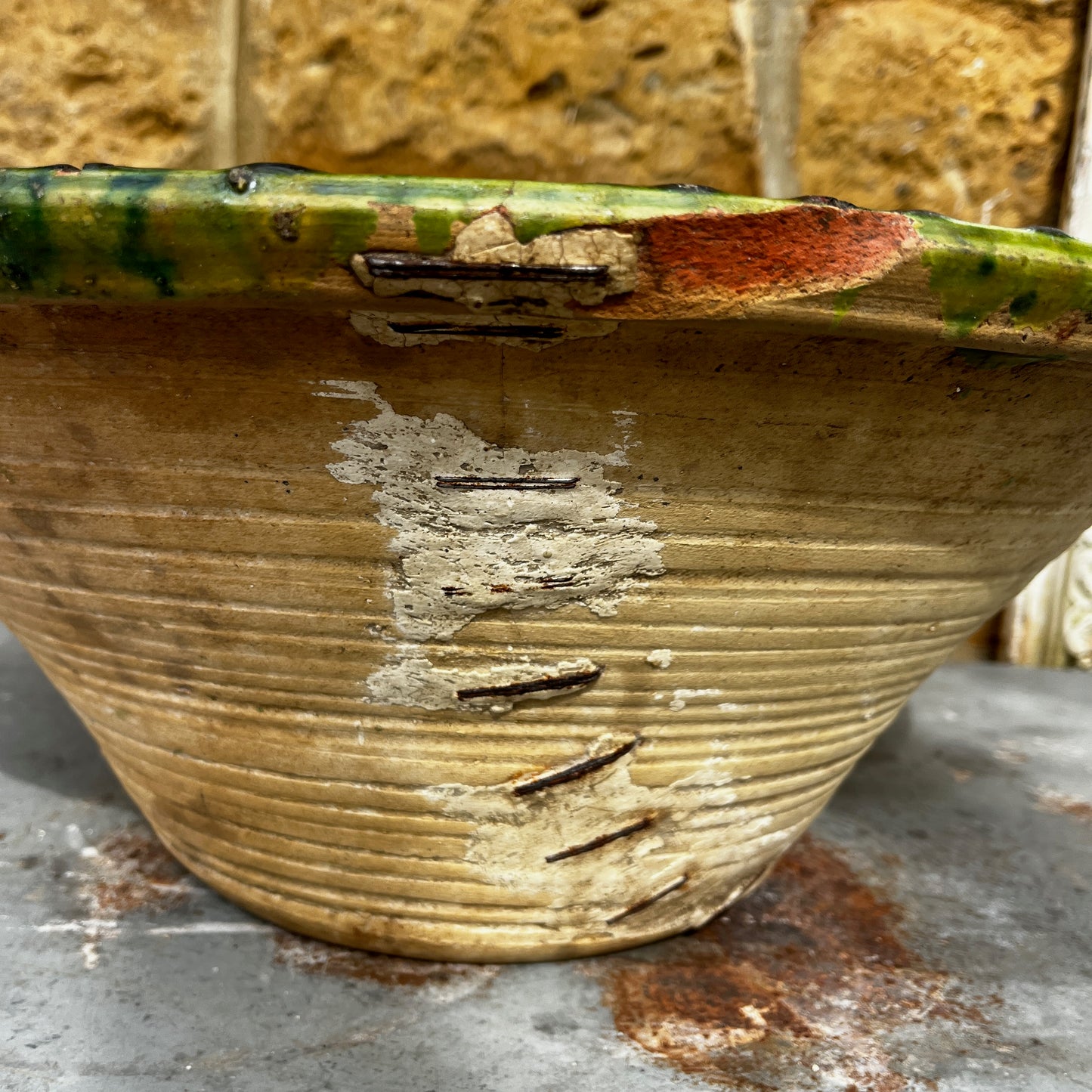An 18th-century Tian bowl in glazed green earthenware with a simple, hand-crafted form and richly aged finish. The bowl features a wide, gently flared rim and a deep rounded shape, showcasing subtle variations in the green glaze that reflect its age and traditional craftsmanship