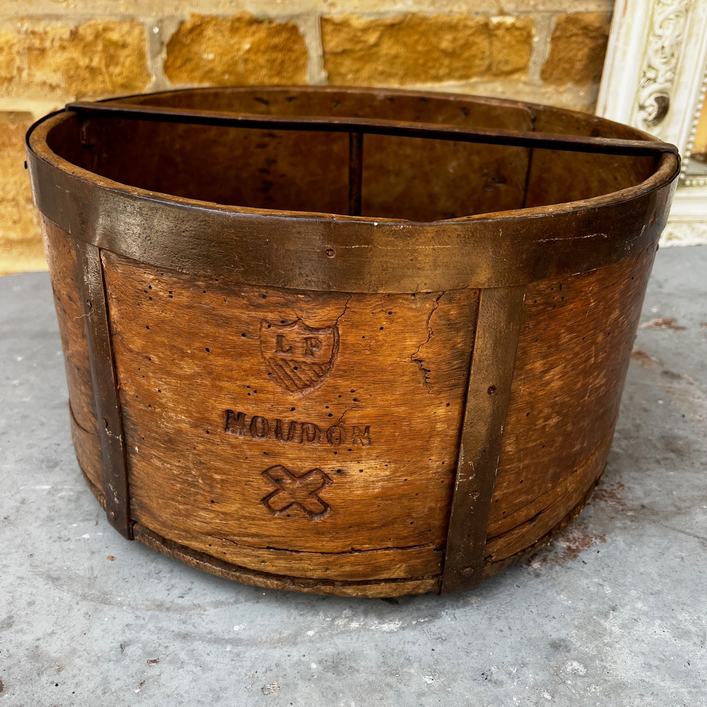 An antique English wooden dry measure with a simple cylindrical shape and a richly weathered natural wood finish.