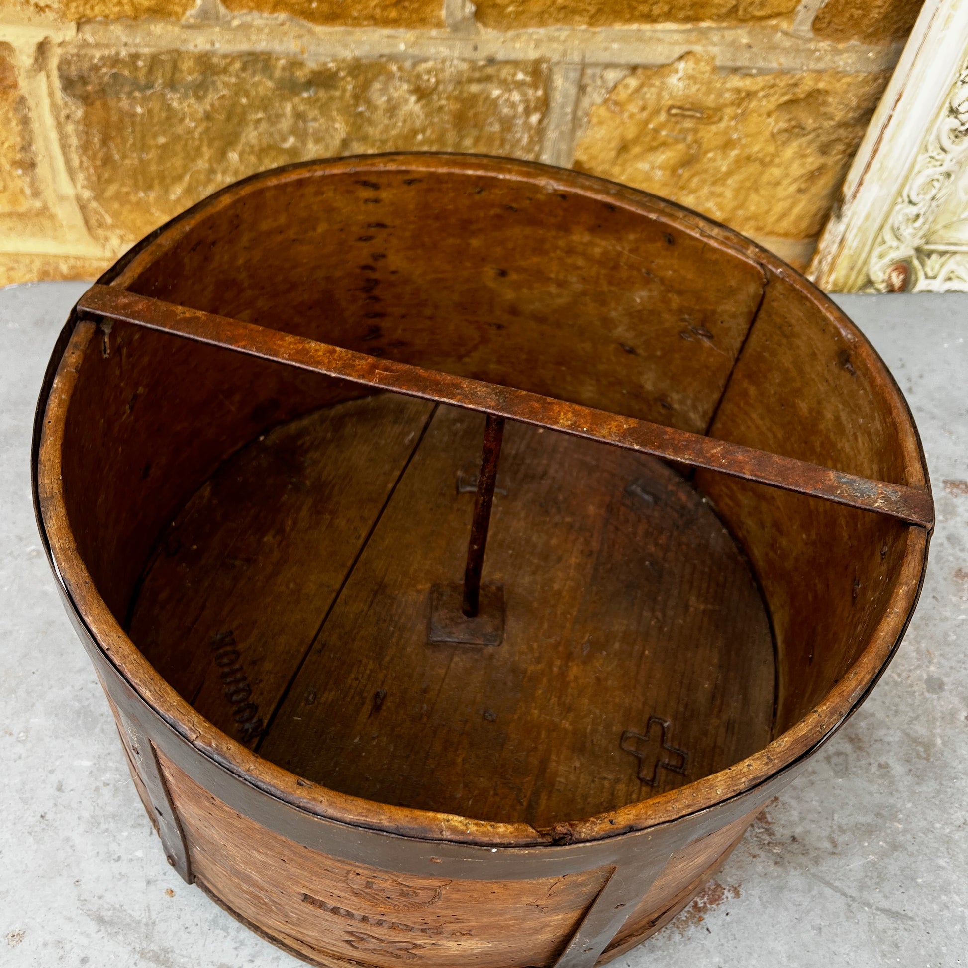 An antique English wooden dry measure with a simple cylindrical shape and a richly weathered natural wood finish.