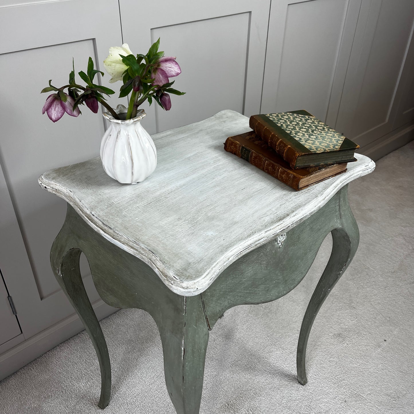 
Gustavian-style bedside table with a single drawer, painted green with a contrasting off-white top, featuring simple classical lines and a softly distressed vintage finish.
