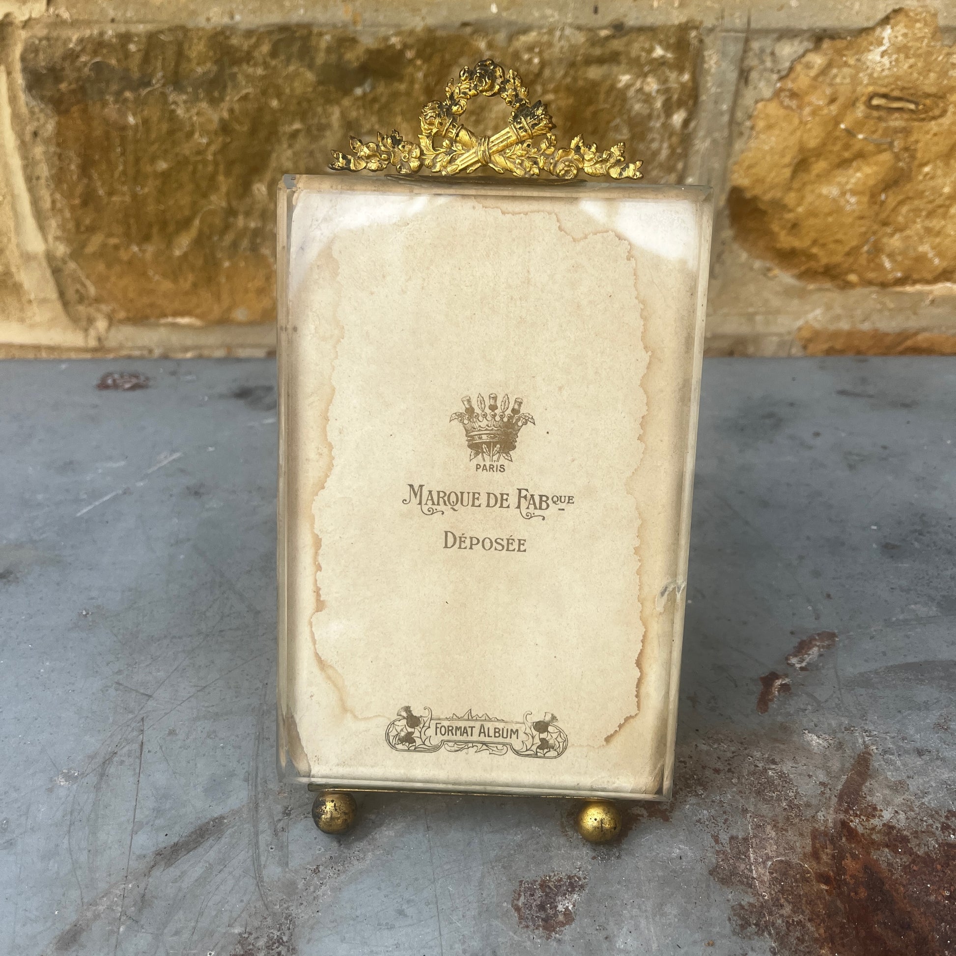 An antique French ormolu and glass photo frame featuring a bevelled glass panel and a richly aged gilt finish with a beautiful antique patina.