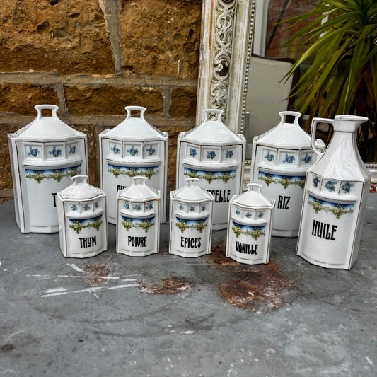 French kitchen storage canisters in white porcelain with blue, green & yellow decorative detailing. The canisters feature classic shapes, hand-painted motifs, and a timeless vintage French country style.