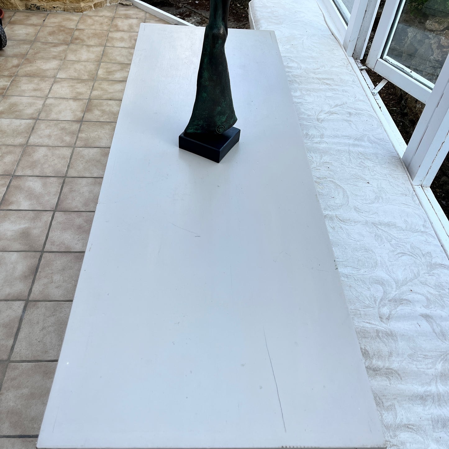 A long grey vintage console table with a weathered finish, featuring a sleek rectangular top and small drawers at each end. The table stands on decorative legs, exuding elegance