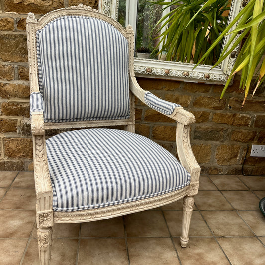 Louis Philippe-style antique chair with a curved wooden frame, featuring newly upholstered blue and white ticking fabric on the seat and backrest.