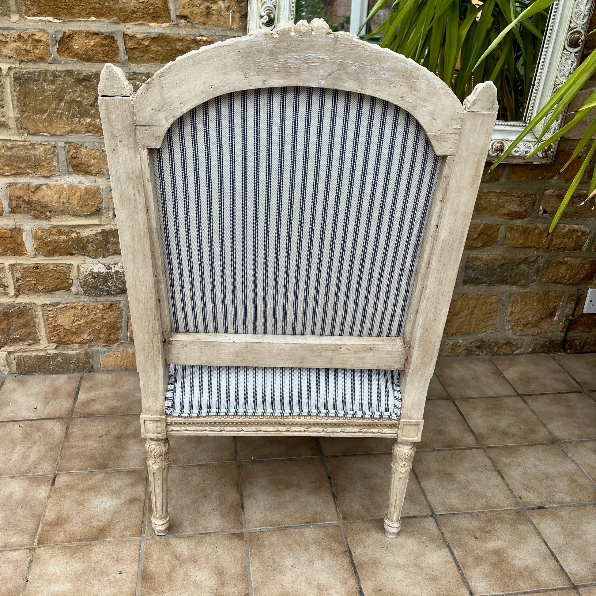 Louis Philippe-style antique chair with a curved wooden frame, featuring newly upholstered blue and white ticking fabric on the seat and backrest.