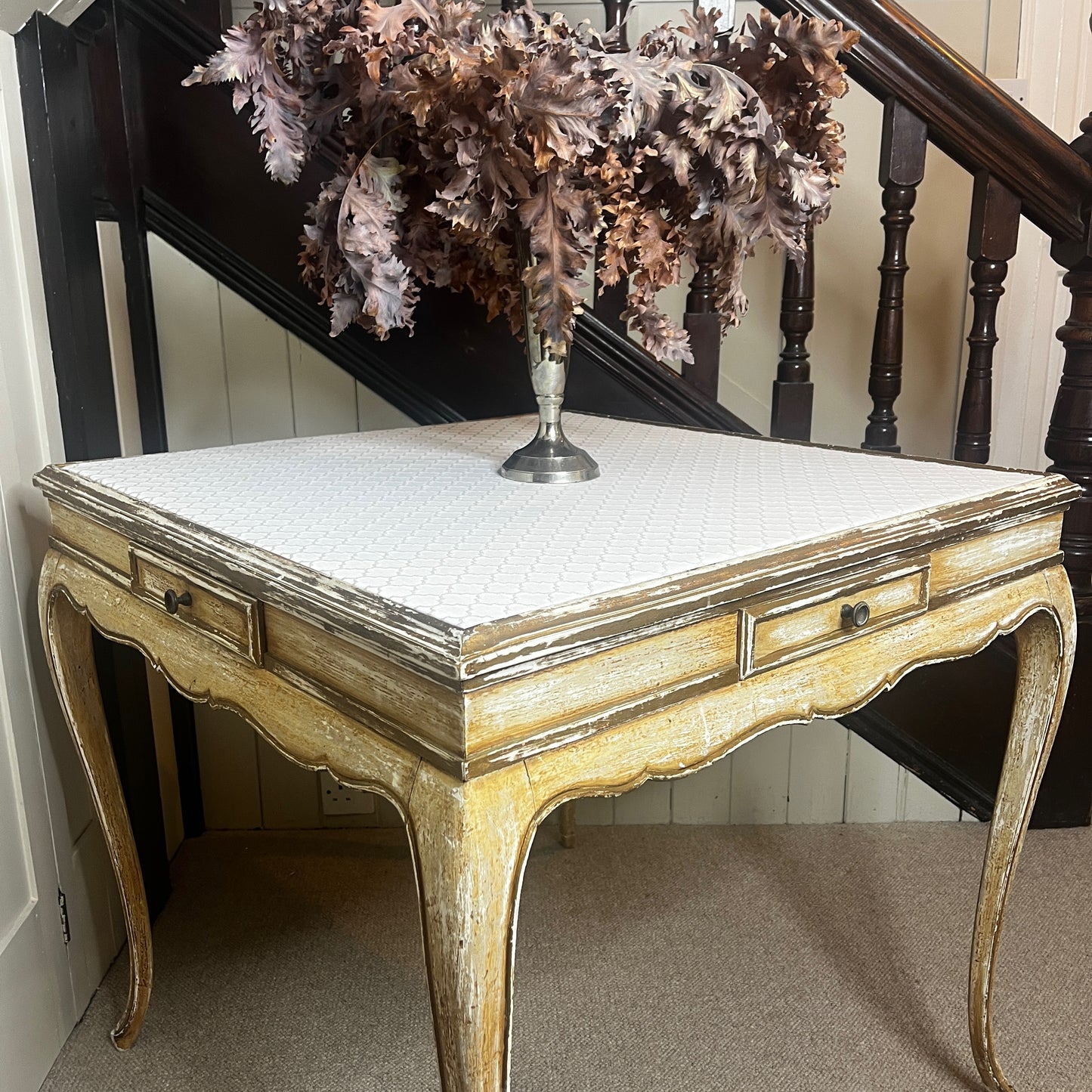 Square Louis-Philippe–style table with a warm wood finish, featuring clean classical lines, gently rounded edges, and small drawers built into all four sides, supported by four turned legs.
