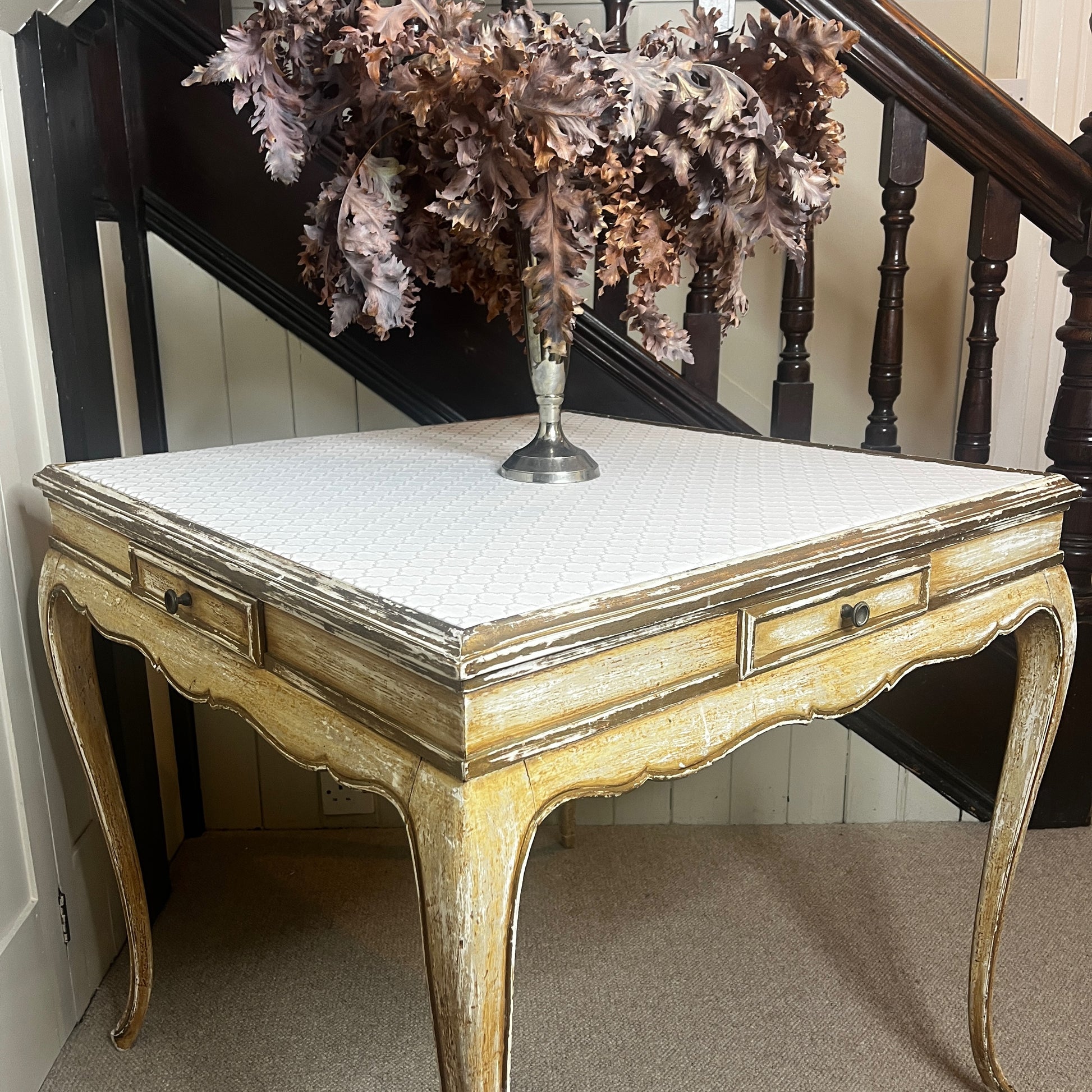 Square Louis-Philippe–style table with a warm wood finish, featuring clean classical lines, gently rounded edges, and small drawers built into all four sides, supported by four turned legs.
