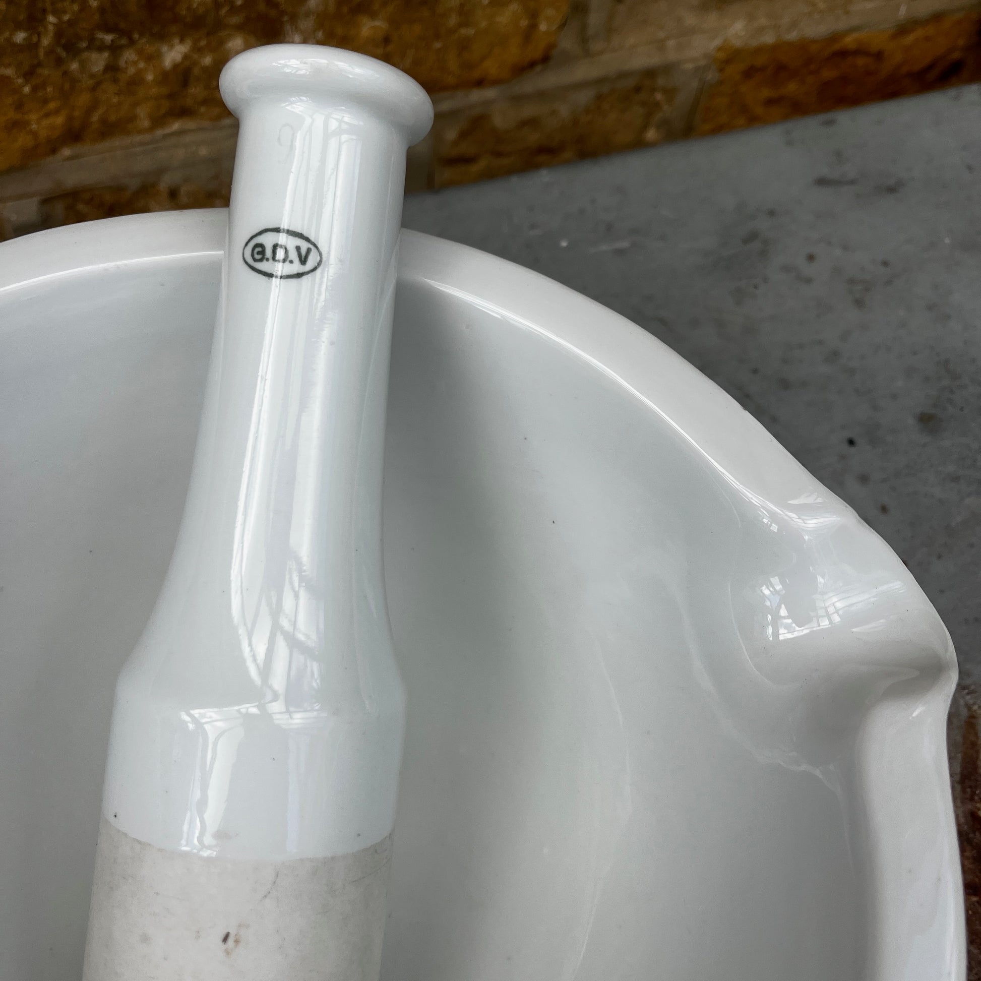 A large vintage GDV porcelain pestle and mortar with a classic white glazed finish and substantial, heavy design. The deep bowl features a pouring lip and sturdy rounded base, accompanied by a matching porcelain pestle